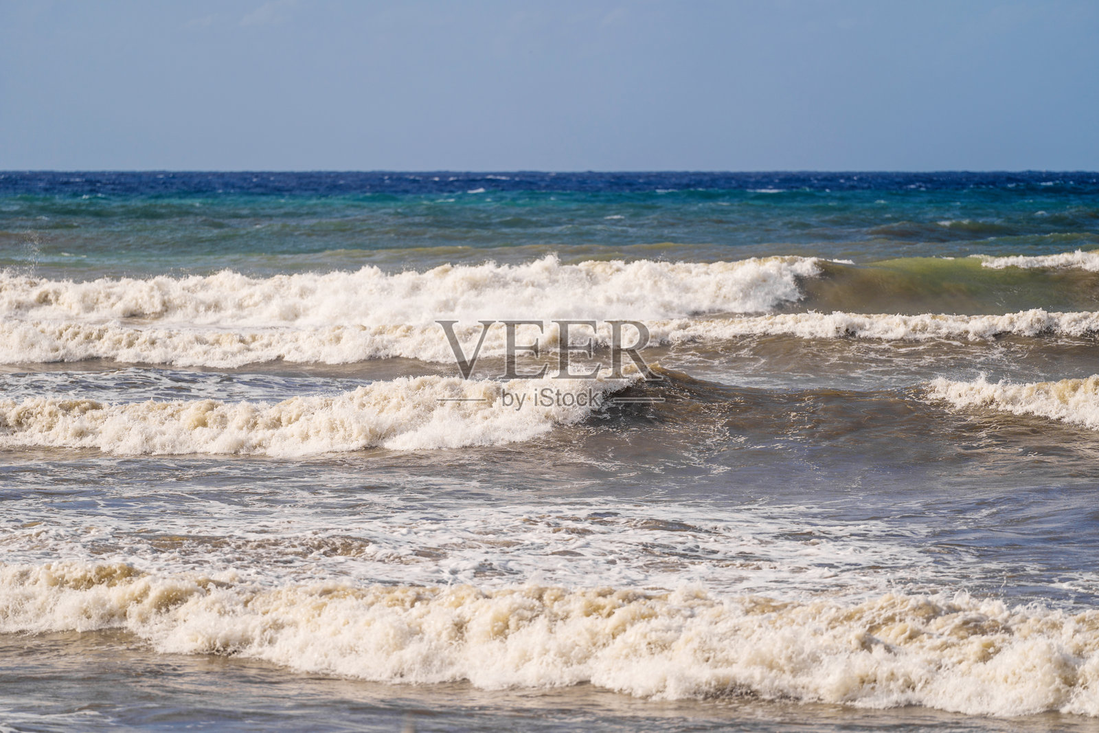 波涛汹涌的海面上,海浪拍打着岸边照片摄影图片