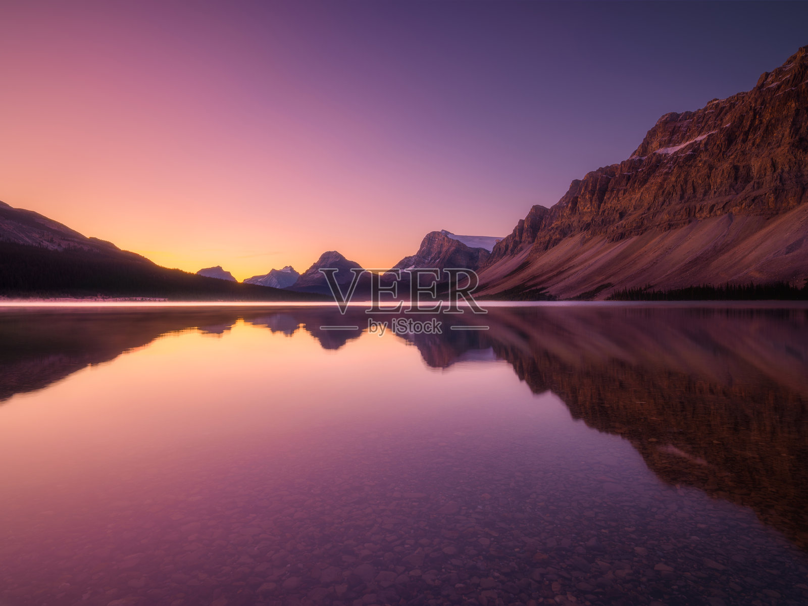 黎明时分的山景。山谷里的阳光。黎明时分山谷中的湖泊和高峰。照片摄影图片