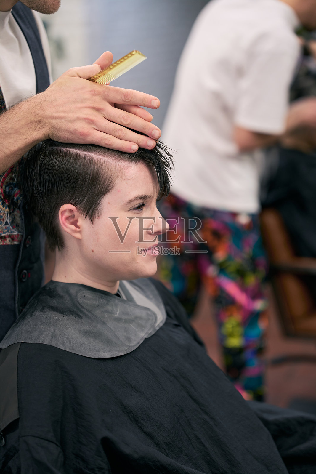 发型师在沙龙为顾客梳头发照片摄影图片