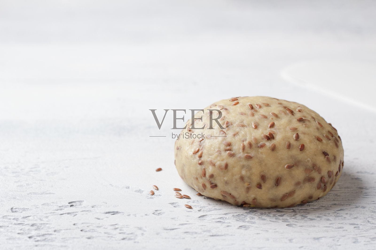 淡蓝色背景上的素食生面团,撒有亚麻籽,留有空白空间。健康的自制食品照片摄影图片