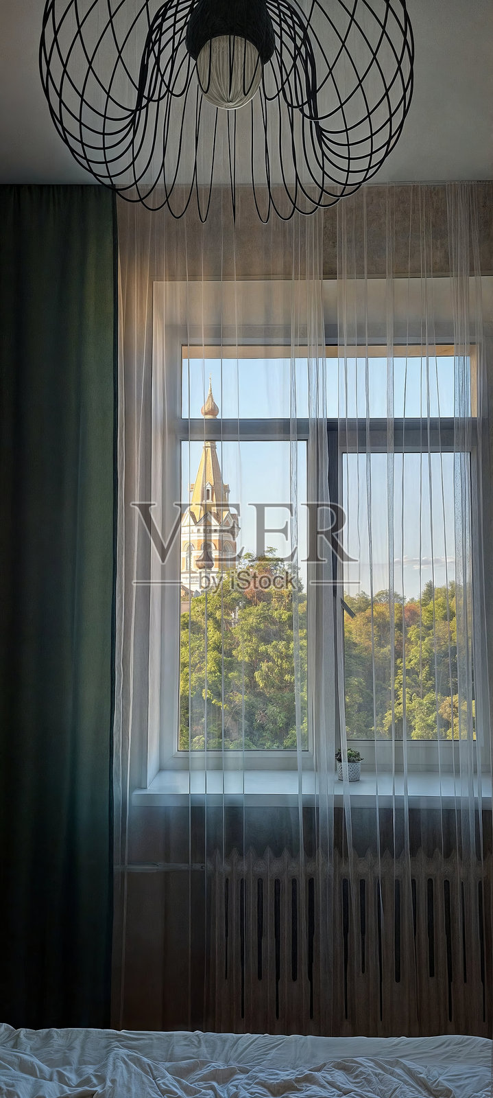 带窗户和枝形吊灯的主卧室。照片摄影图片