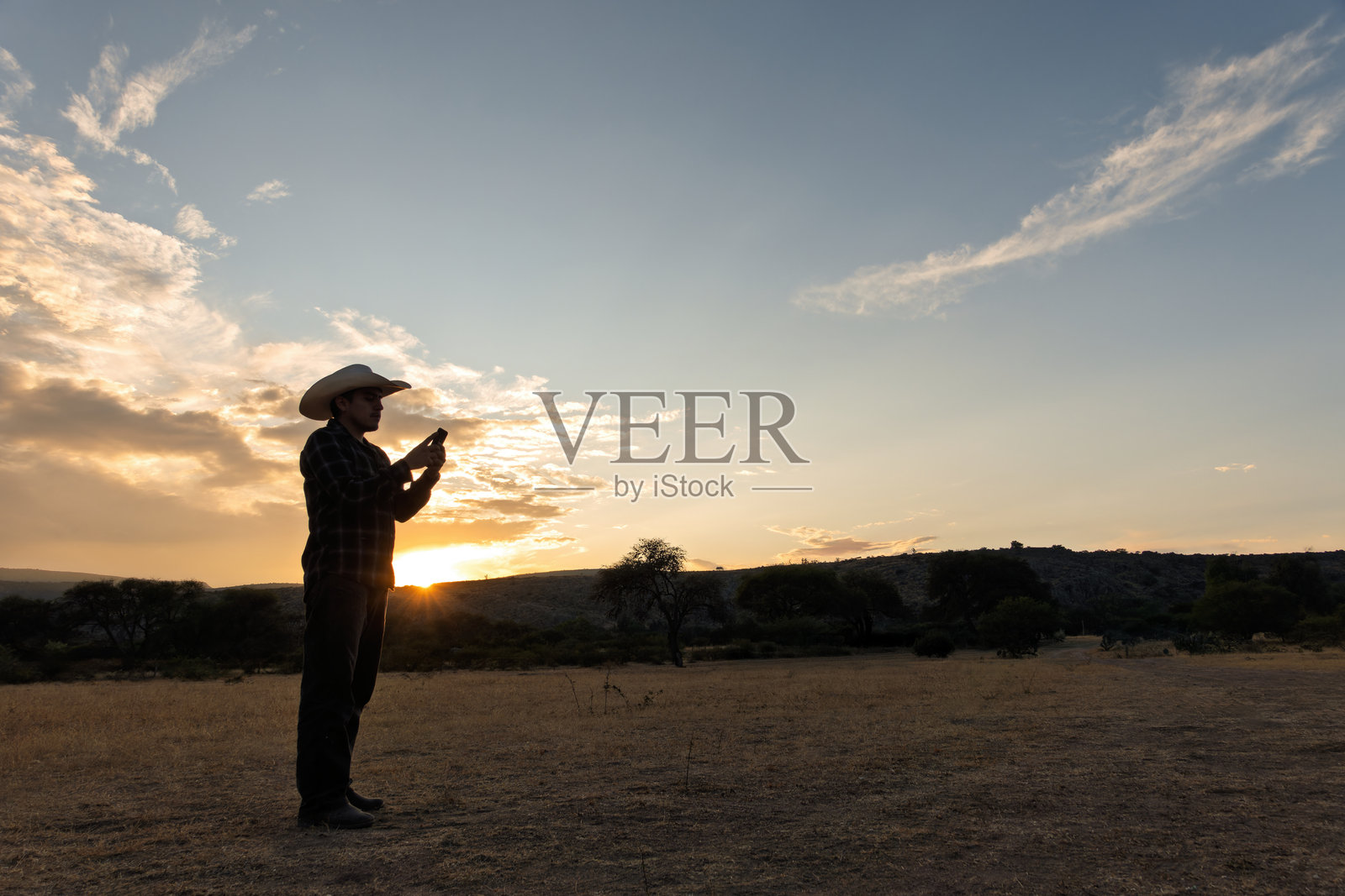 墨西哥牛仔在日落时分为乡村的一天做准备照片摄影图片