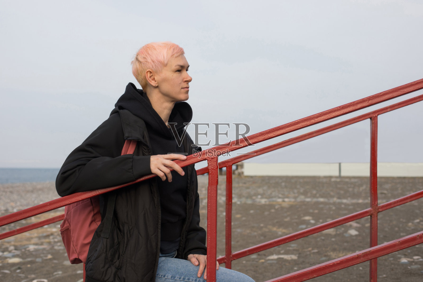 自信的短发女性微笑着,站着并看向镜头,户外肖像照片摄影图片