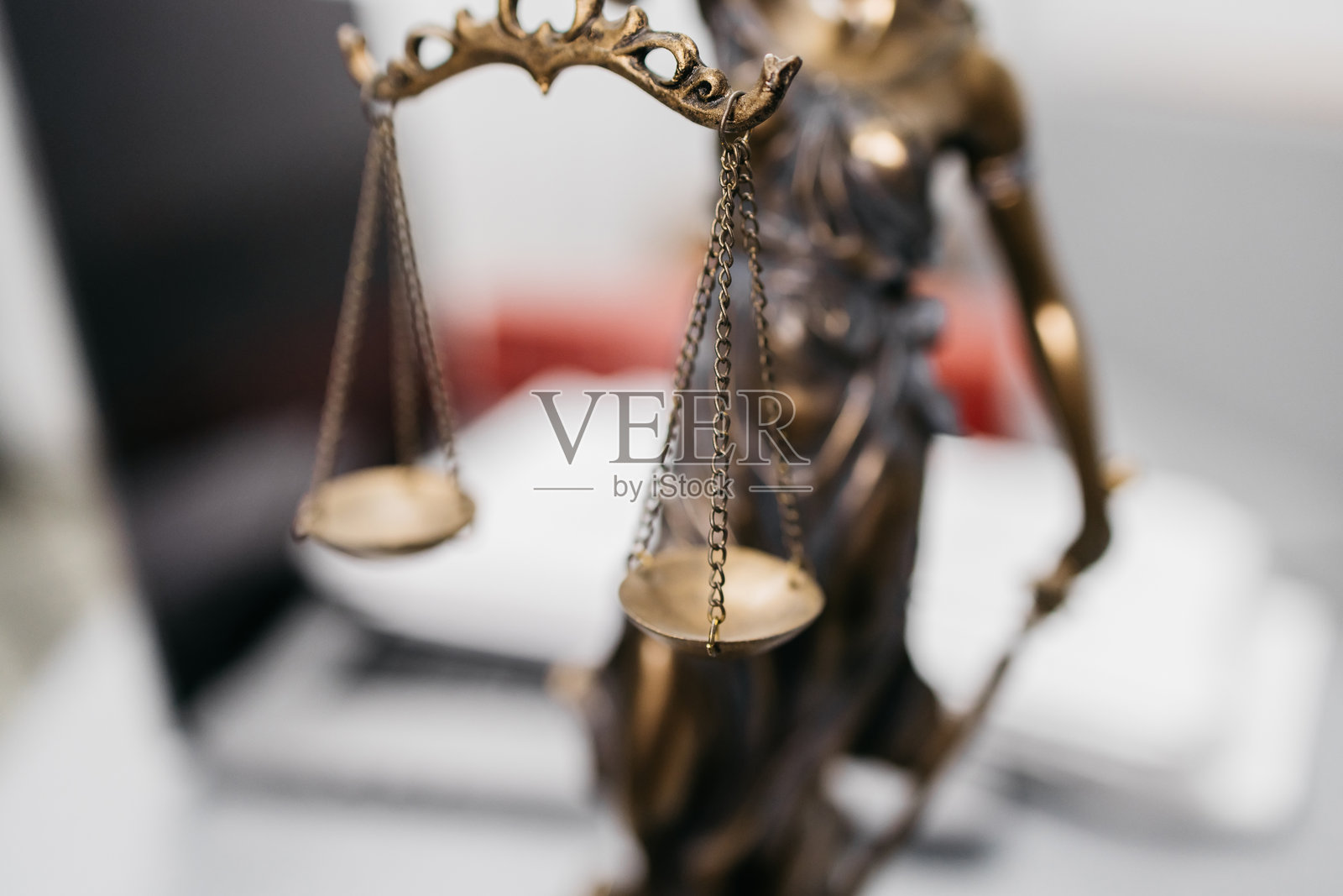 律师的桌子上有合同文件、一台笔记本电脑和一尊正义女神的雕像。照片摄影图片