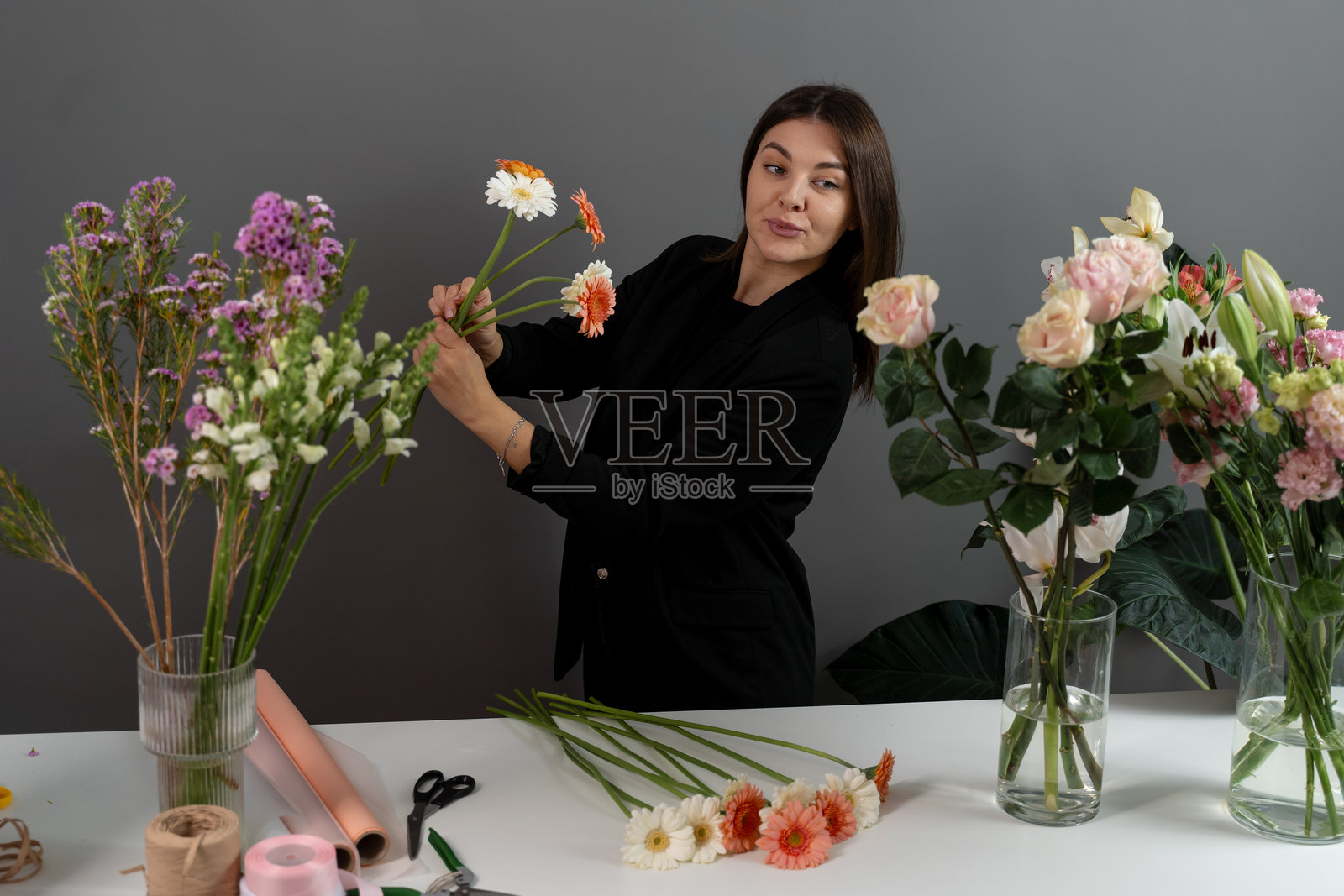 花店的花艺师正在采集雏菊制作花束,为顾客制作由大丽花组成的花卉作品。照片摄影图片