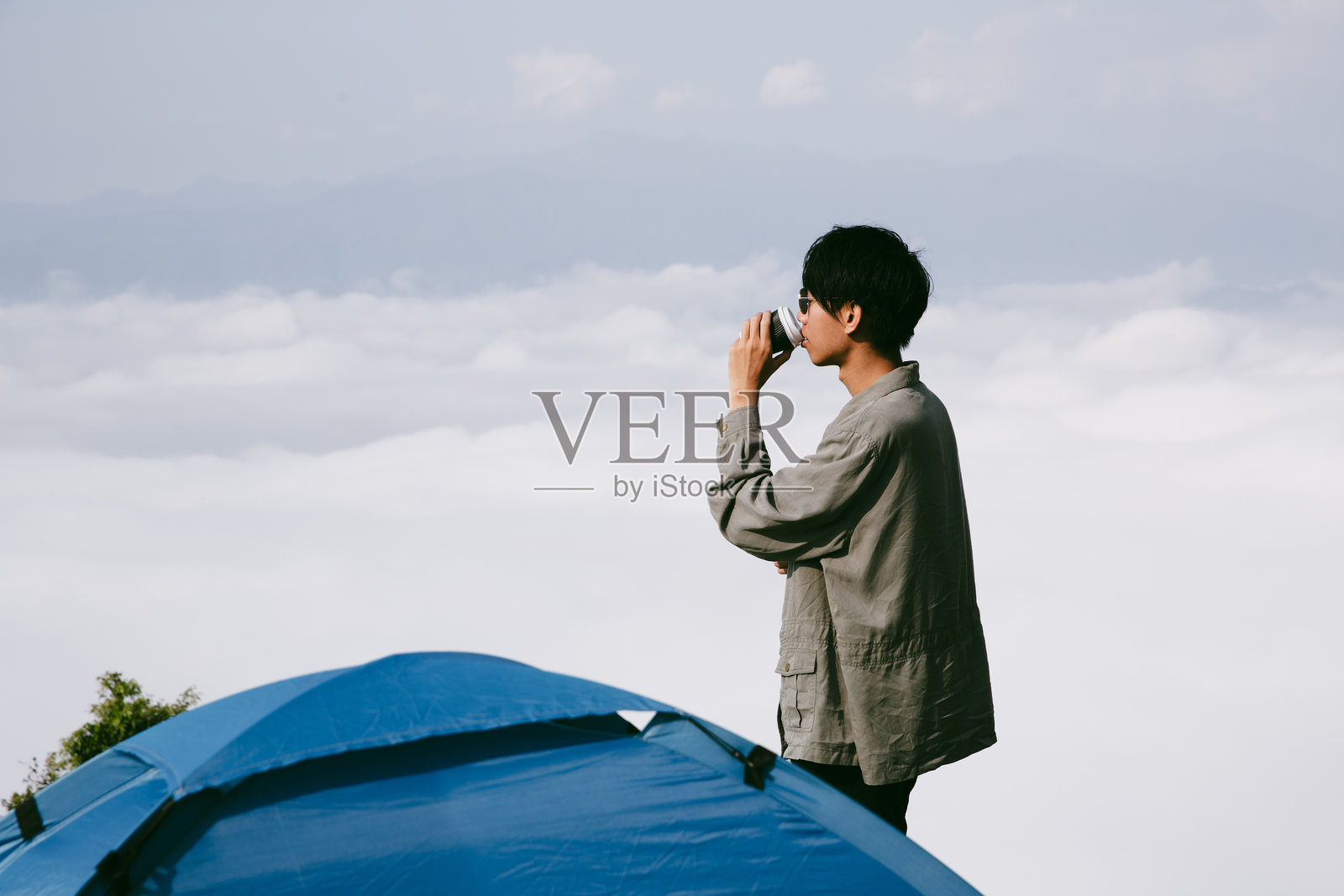 背包客男性在户外徒步旅行,享受旅行生活方式和冒险概念。戴着帽子的背包客与其他游客一起参加绿色山脉之旅,感受大自然的美丽和广阔的天空。照片摄影图片