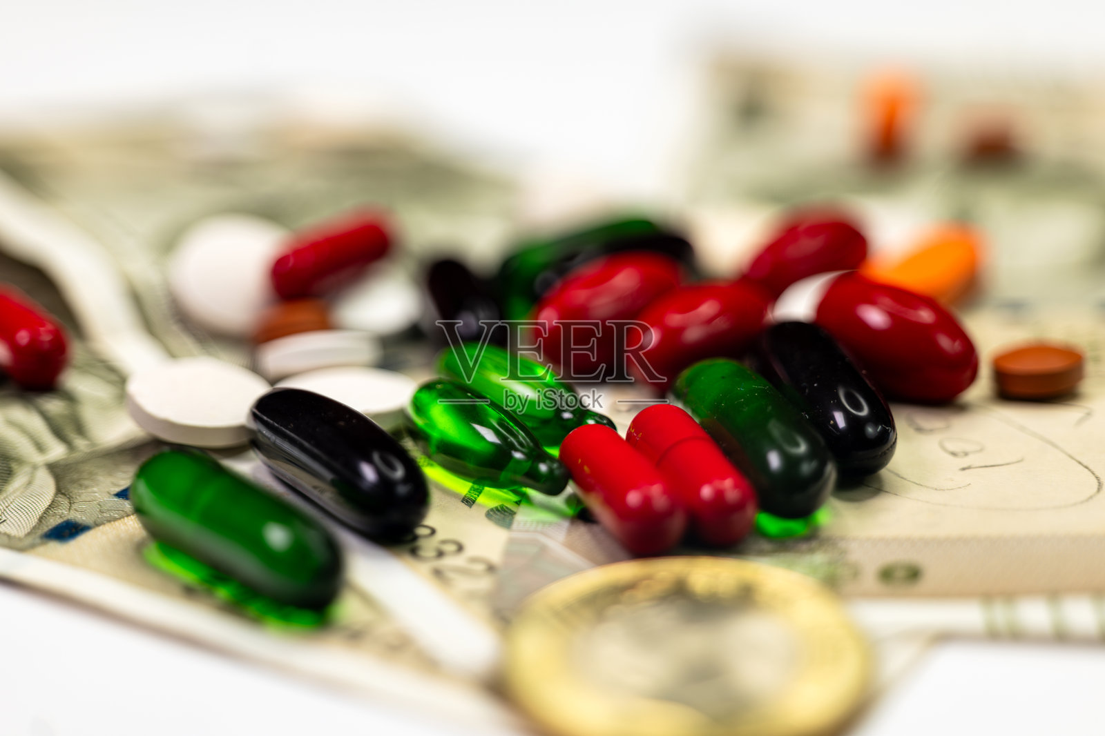 特写的印度500卢比和彩色药丸上面有10卢比硬币照片摄影图片