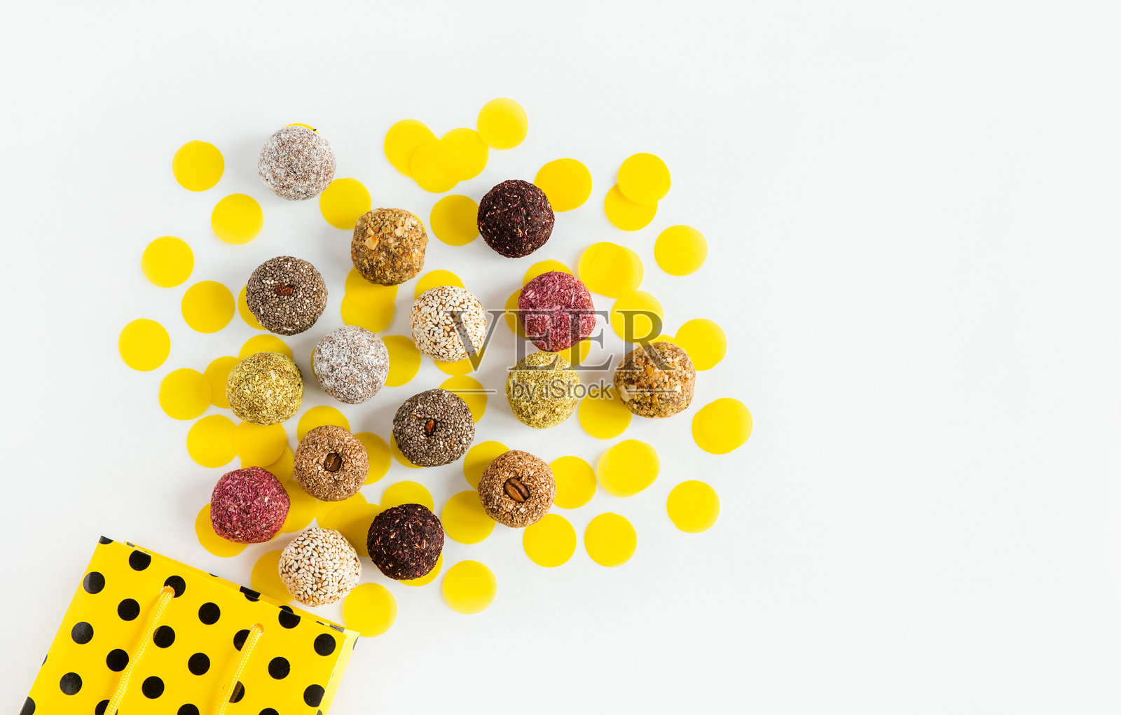 健康的糖果,用天然原料制成的糖果。,从黄色的节日袋中取出。素食有机食品。白色背景,生日和派对的概念。照片摄影图片