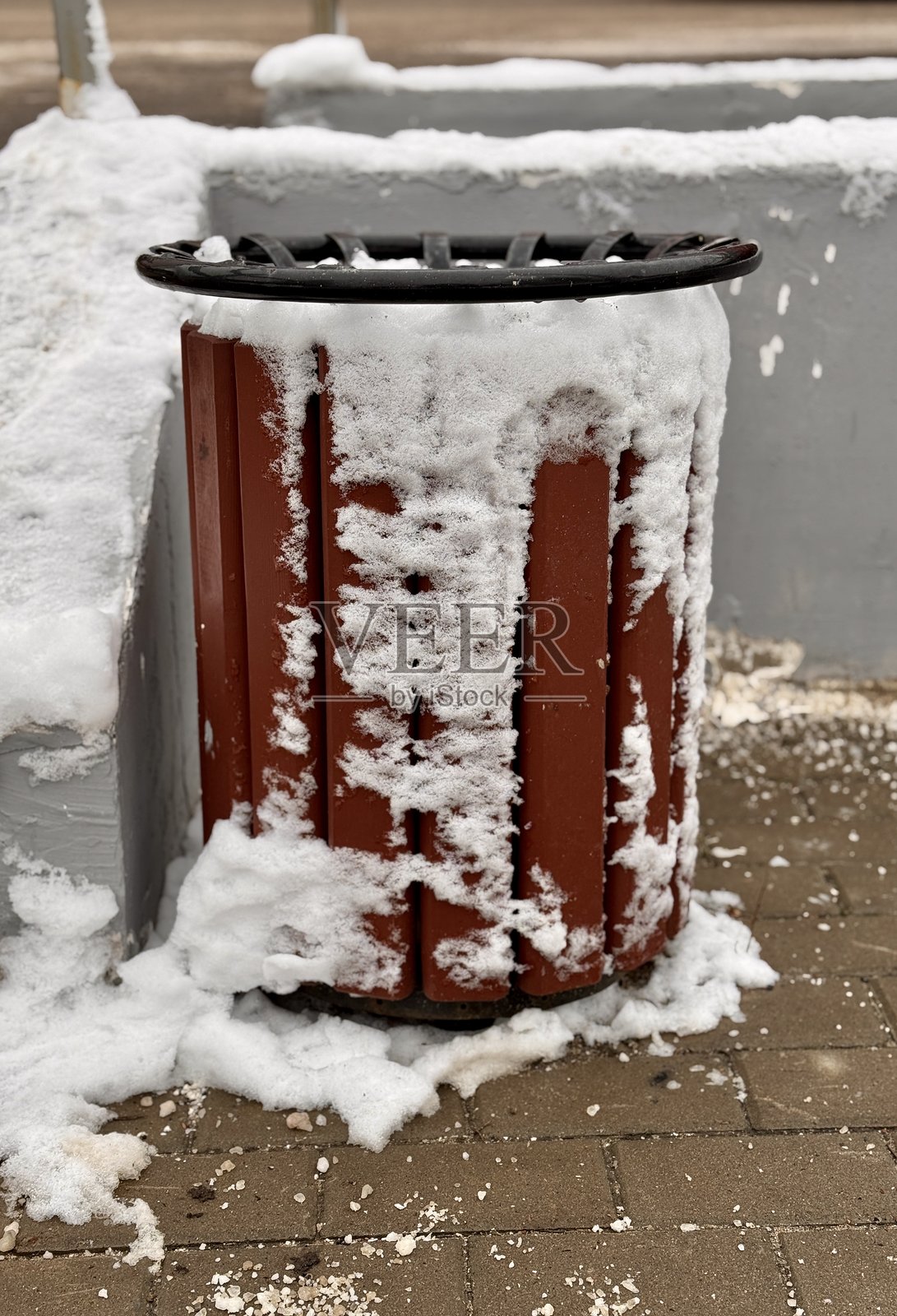 一个乡村风格的垃圾桶,周围被美丽的雪花覆盖,映衬出城市的生机。照片摄影图片