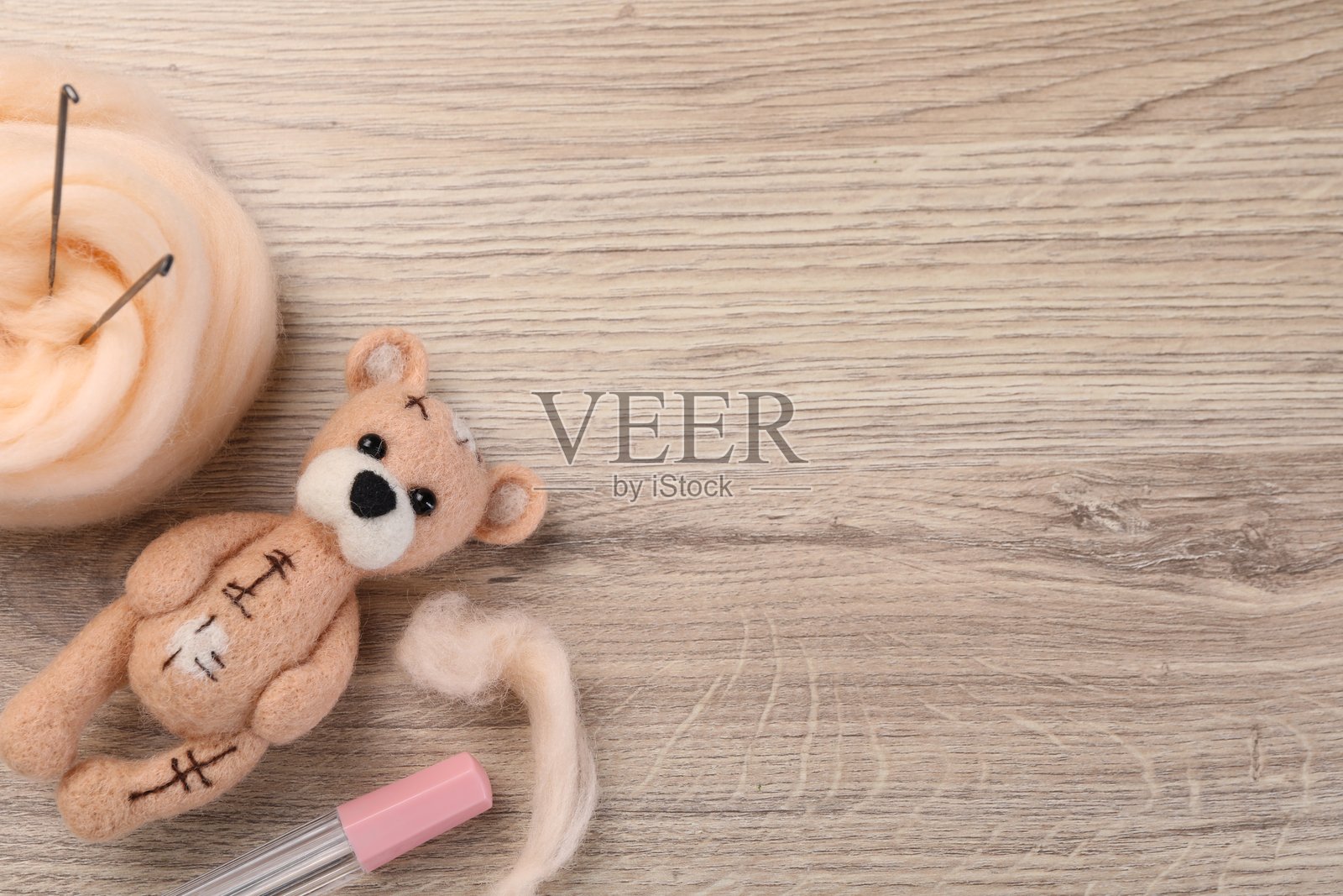 毛毡熊,羊毛和工具放在木桌上,俯视图。留有文字空间照片摄影图片