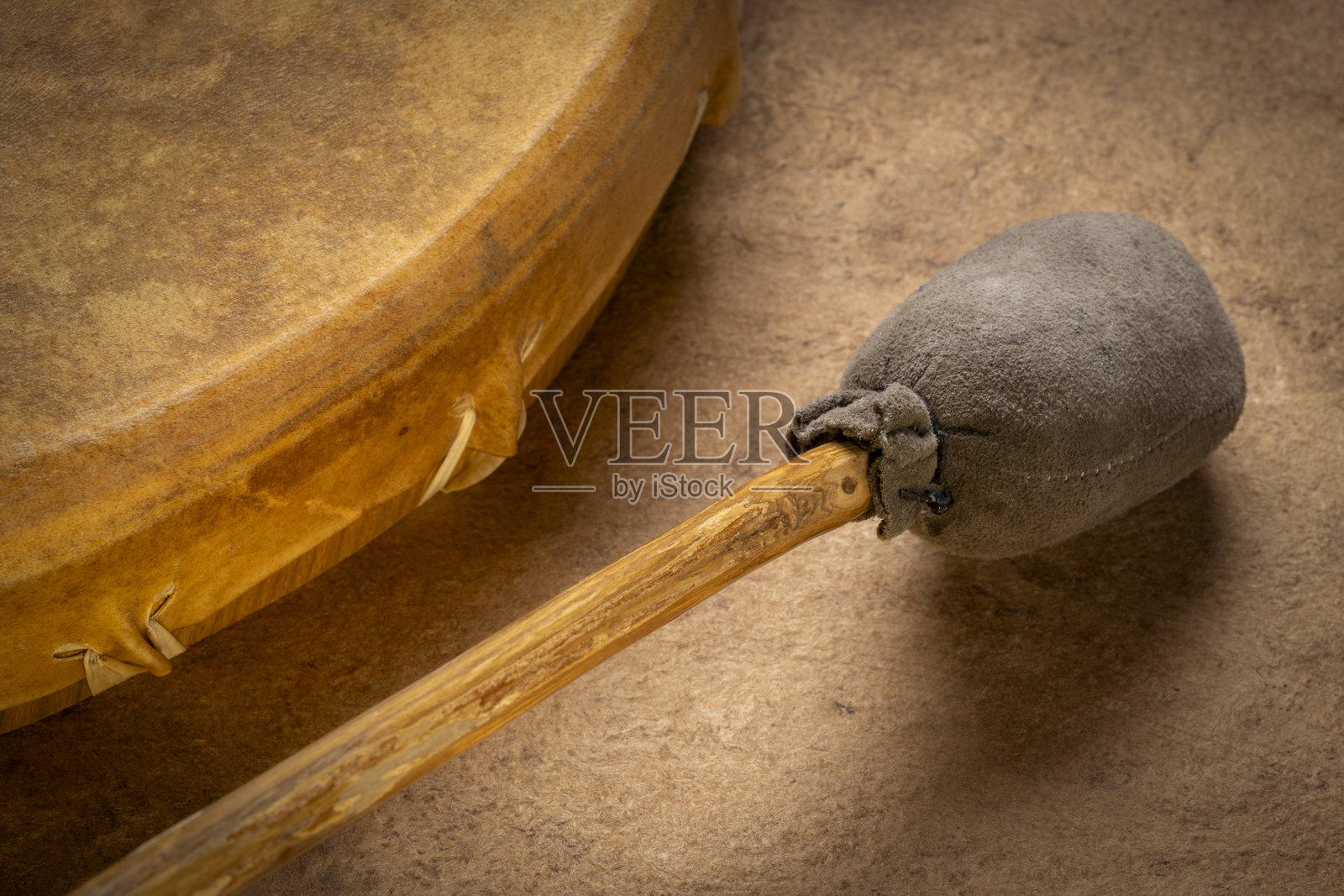 手工制作的美洲原住民风格的萨满框鼓,覆盖着山羊皮,并配有击打棒照片摄影图片