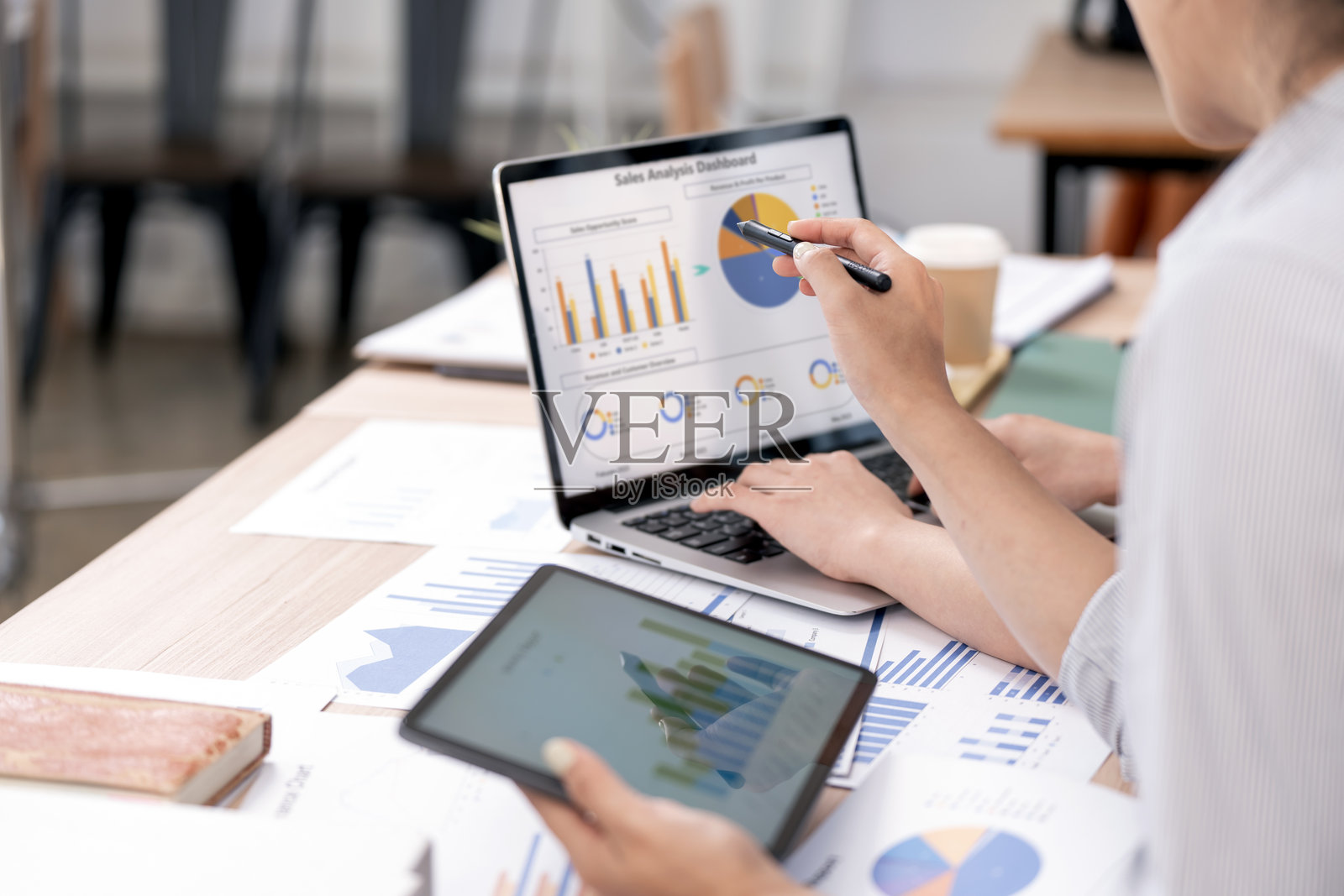 商务人士在办公室桌子上进行咨询会议,讨论和头脑风暴新的商业项目,使用平板电脑和笔记本电脑。照片摄影图片