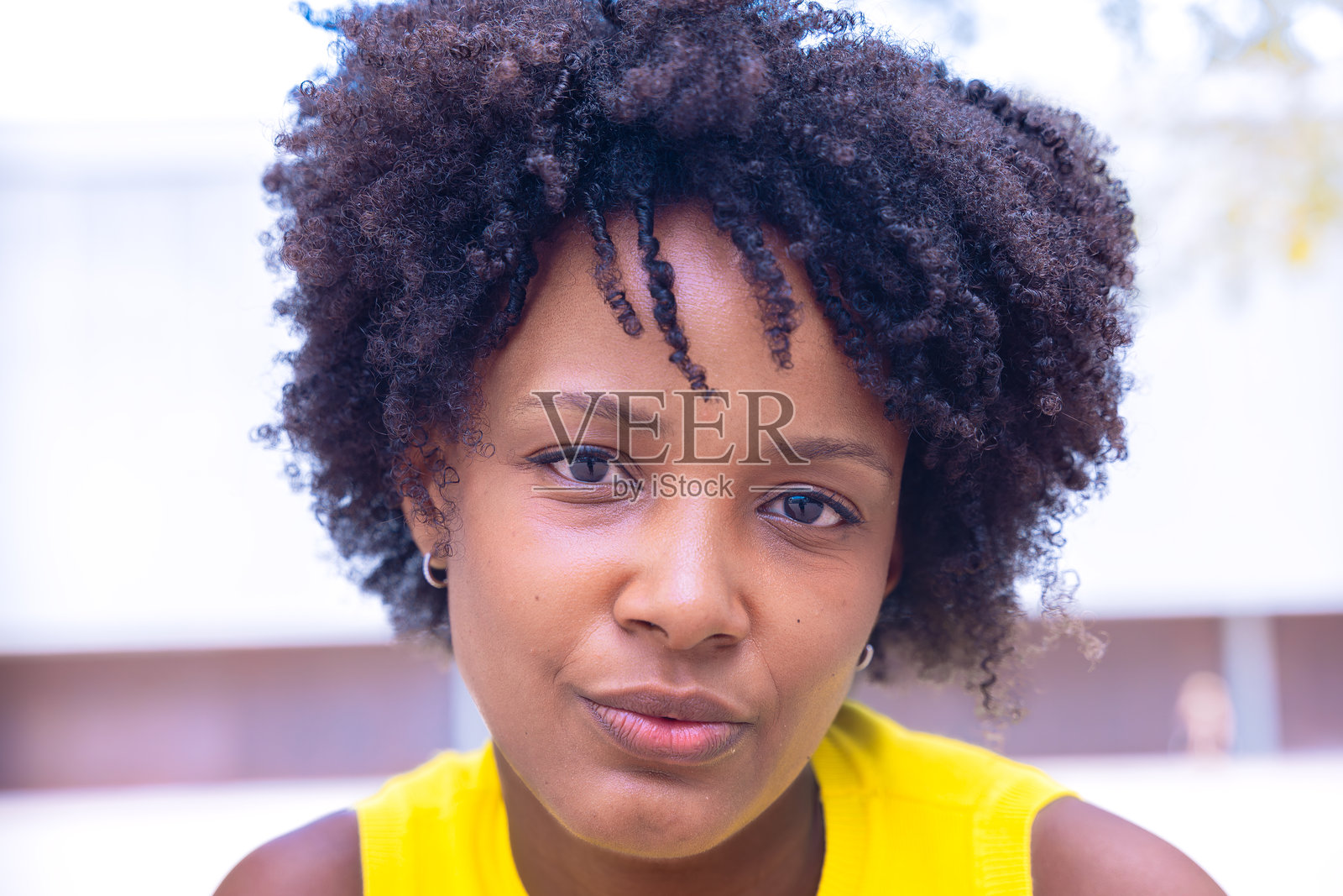 年轻女性的特写肖像,卷发和自信的表情照片摄影图片