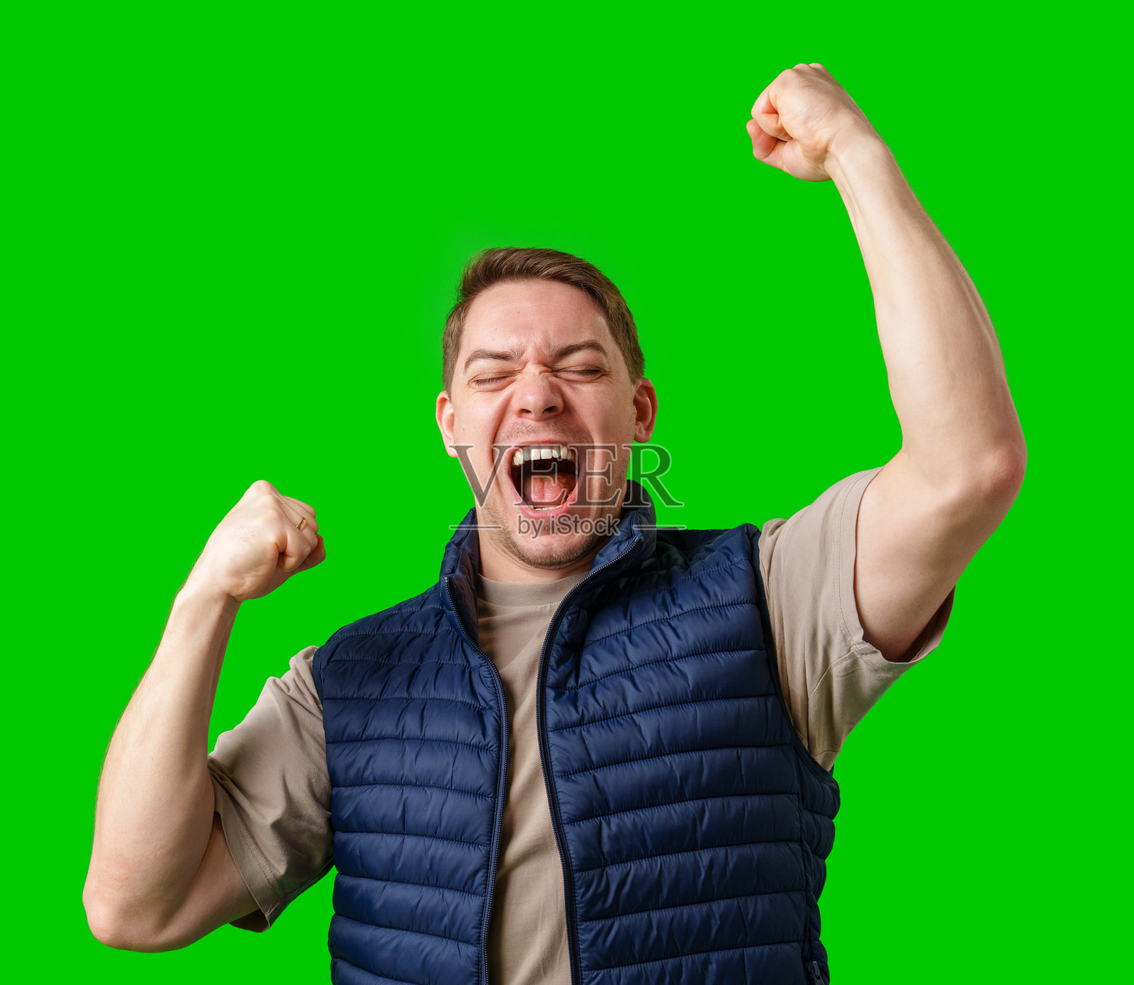 男子在明亮的绿色背景前举起拳头庆祝照片摄影图片