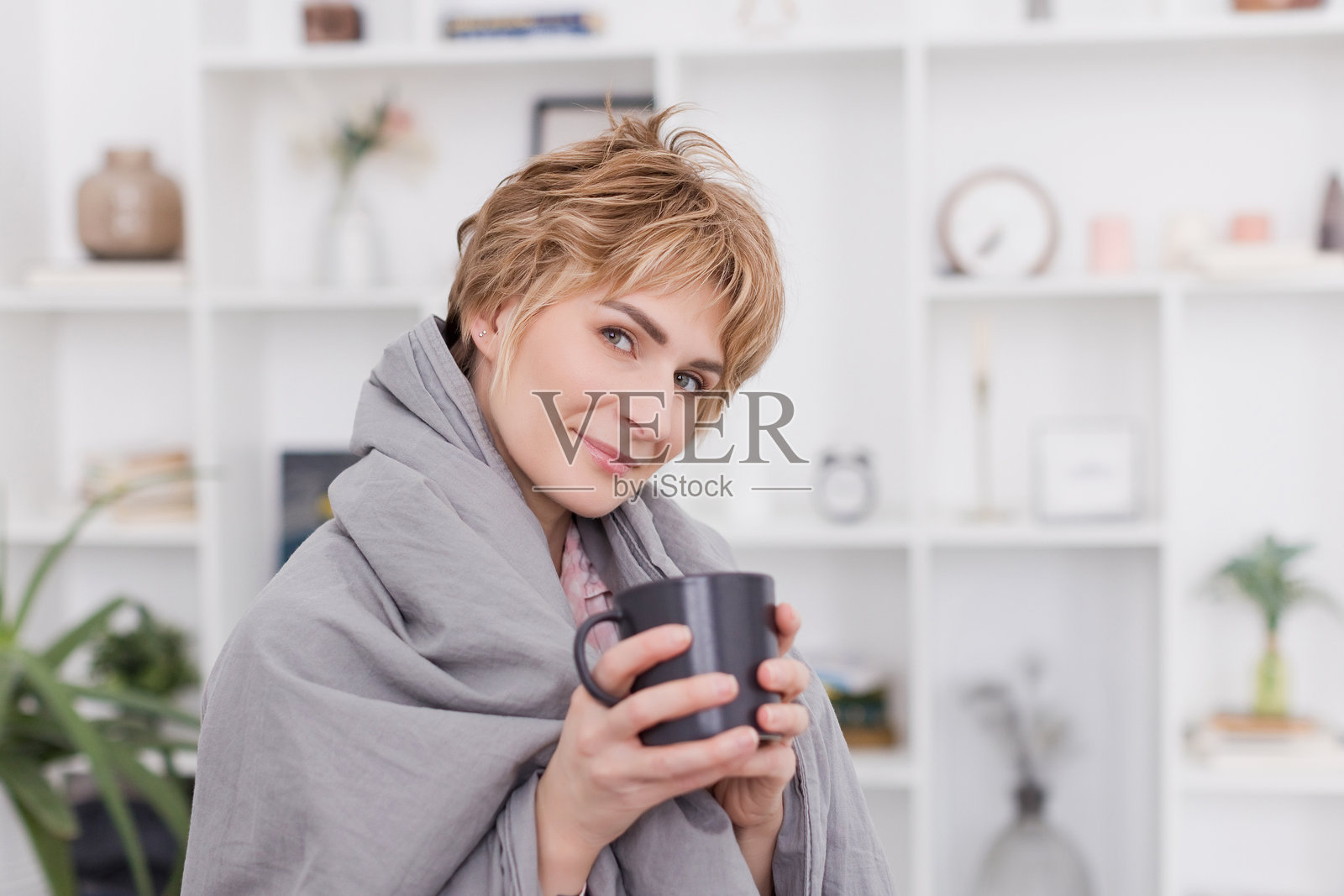 卧室里拿着杯子的金发女人照片摄影图片