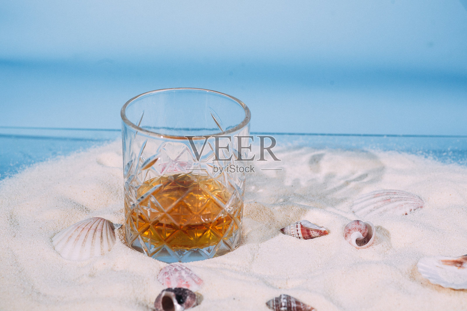 沙滩上的一杯威士忌照片摄影图片