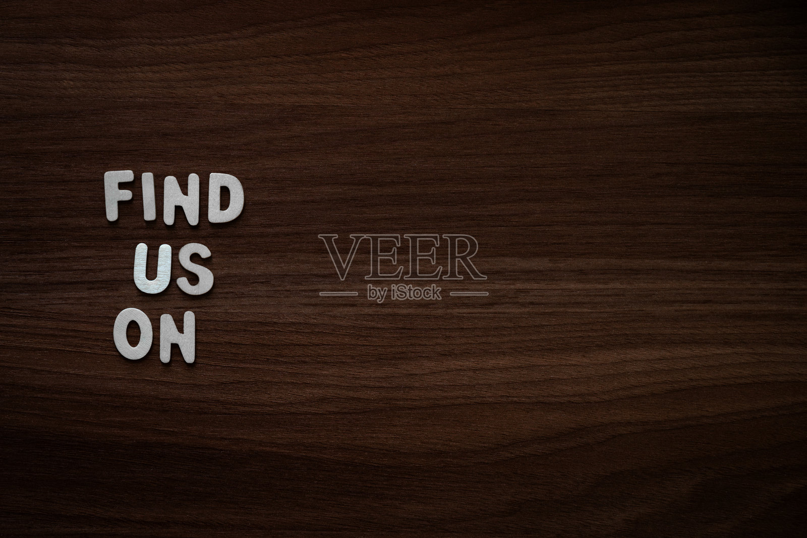 在胡桃木背景上堆叠的木制字母照片摄影图片