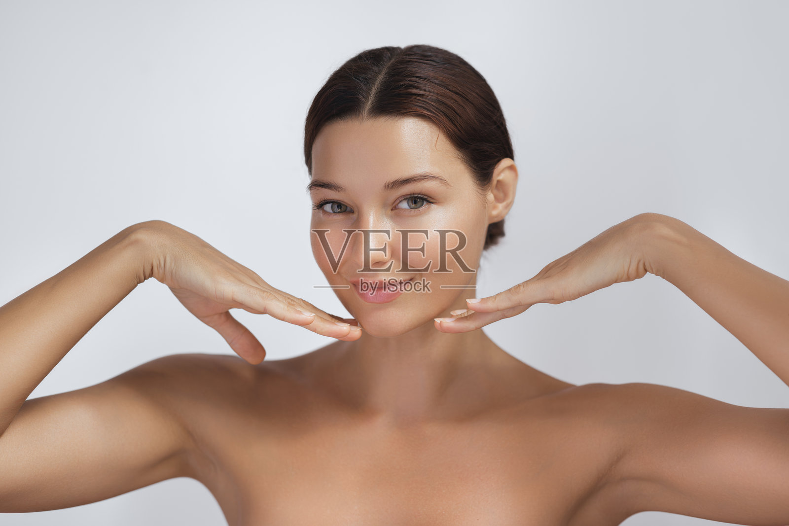 微笑的女性,肌肤光滑,双手托住脸庞摆姿势照片摄影图片