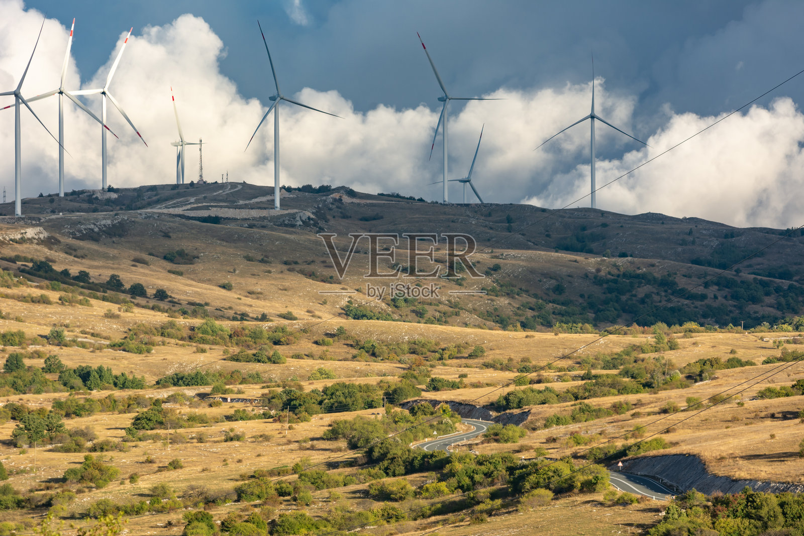 云下的山峰、道路和风电场照片摄影图片