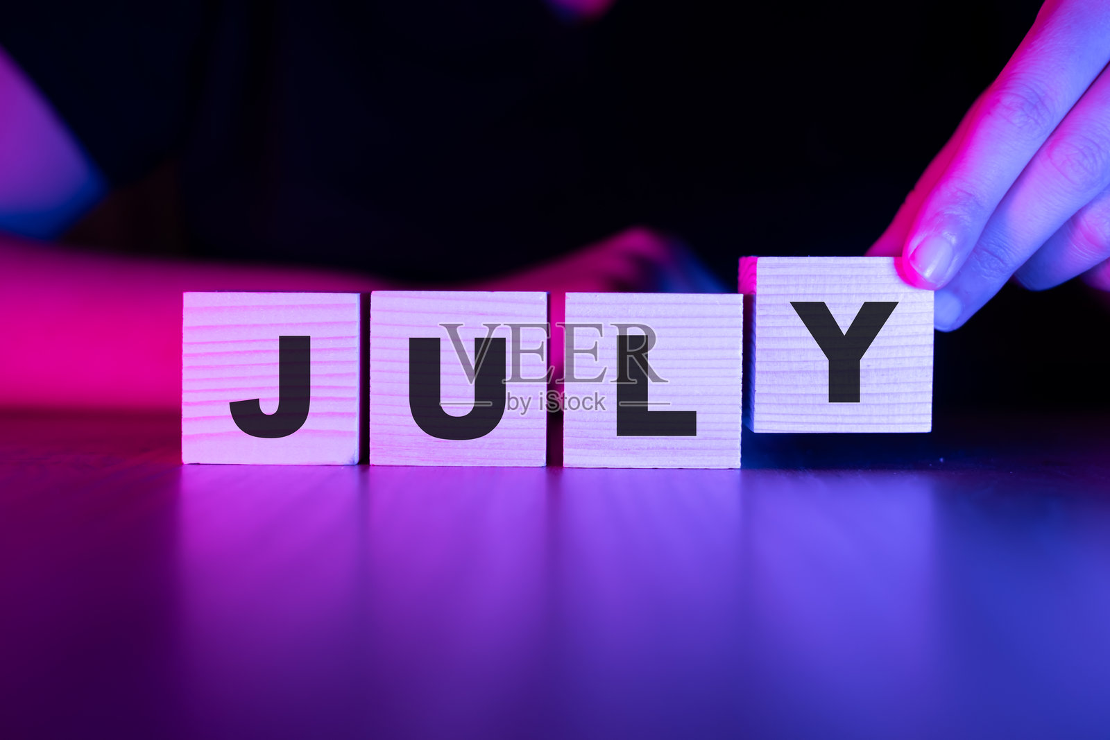 七月字母木块放在桌子上照片摄影图片