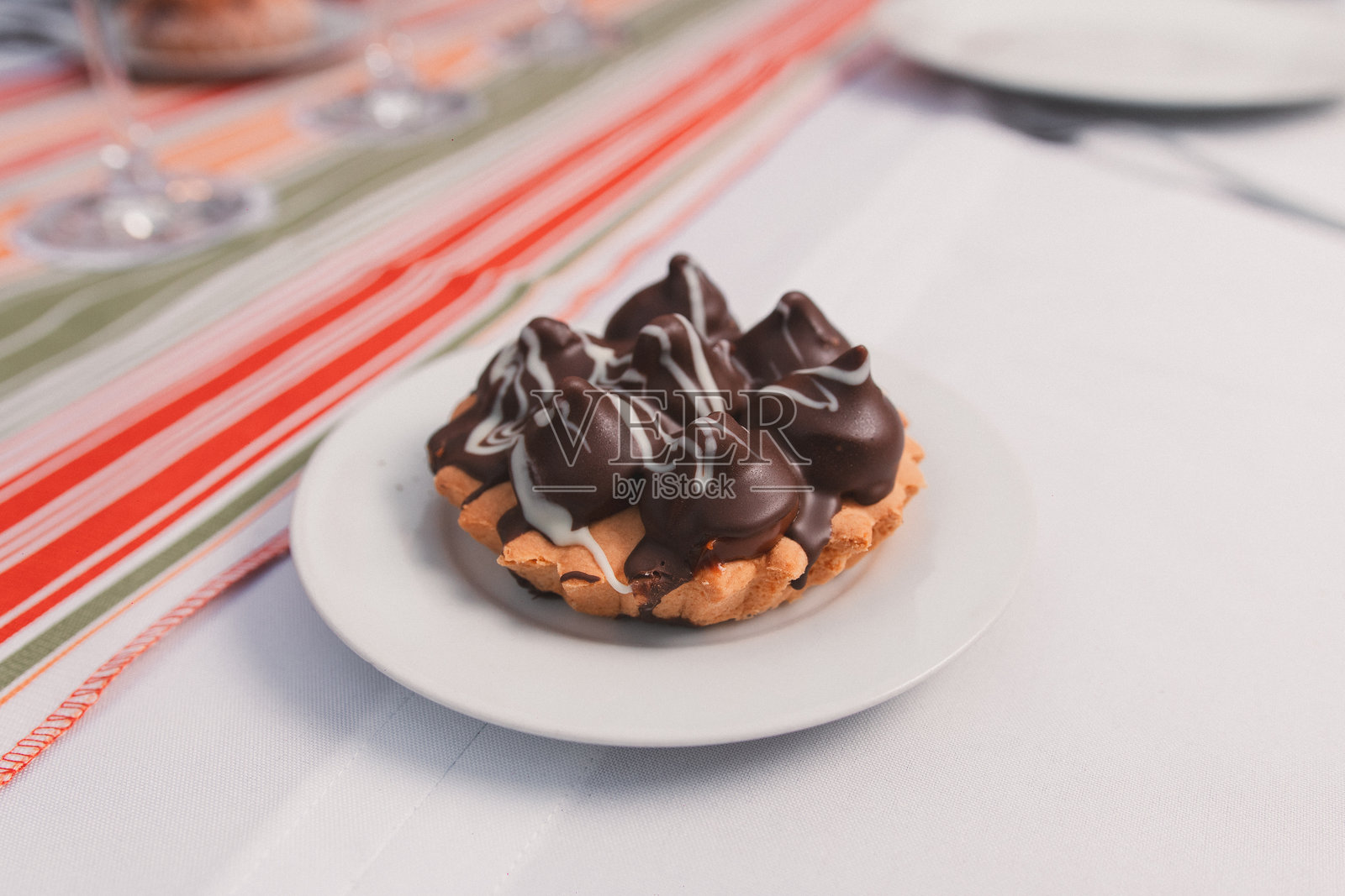 巧克力杯子蛋糕放在桌子上的小白盘里。照片摄影图片