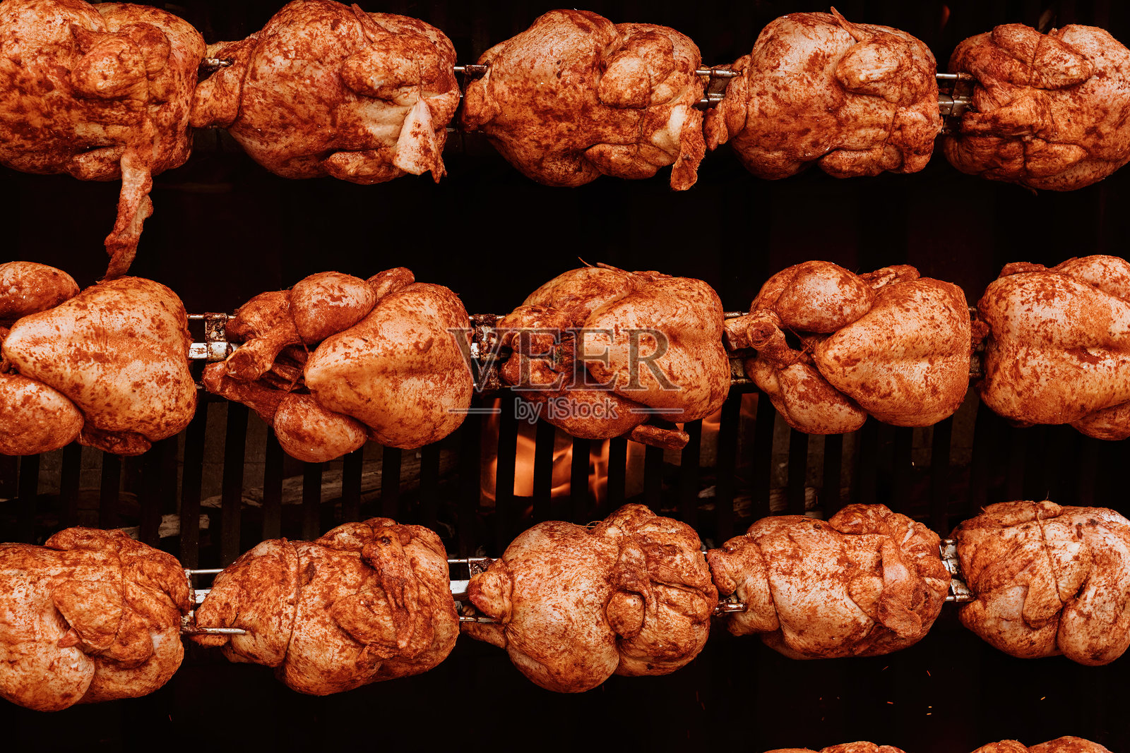 几只鸡在明火上旋转烤制照片摄影图片