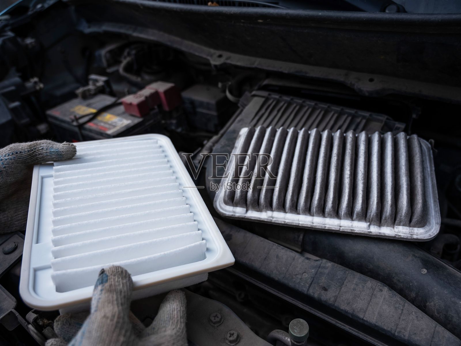 师傅在汽车发动机中更换空气滤清器。照片摄影图片