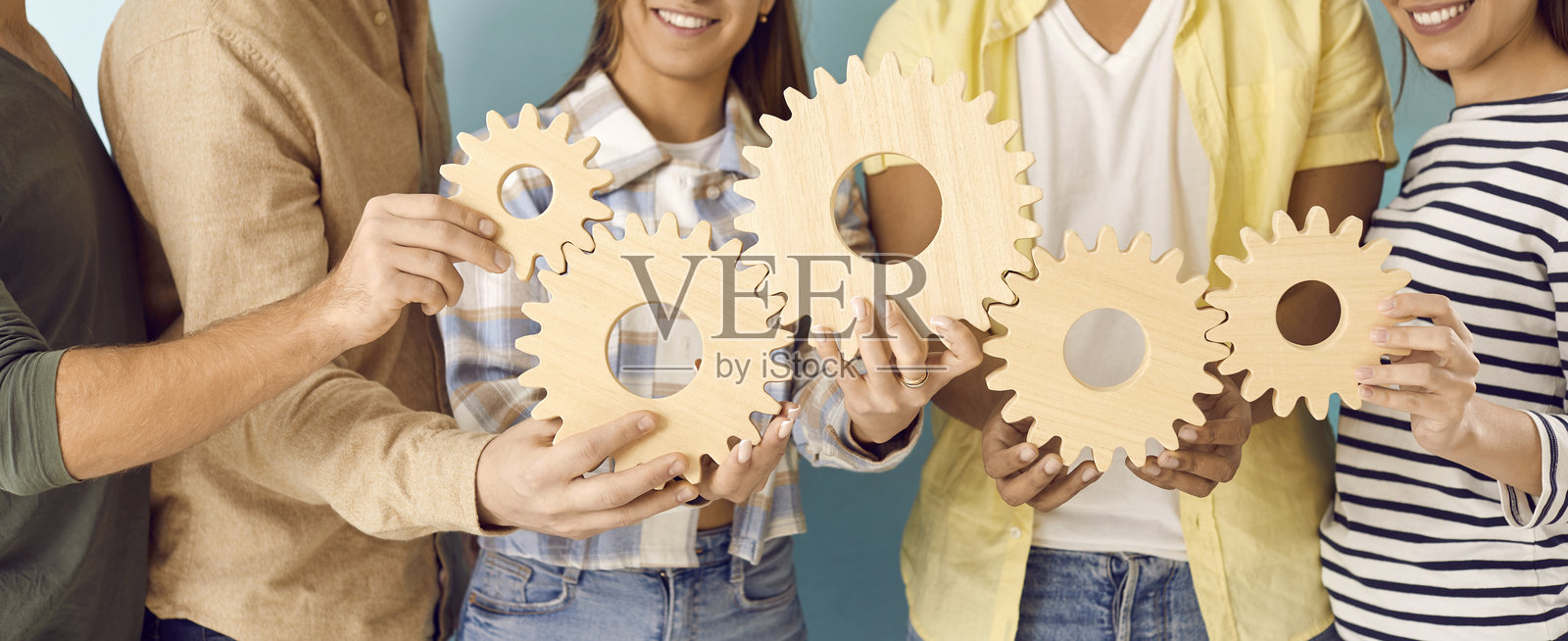 多元化的快乐学生团队正在连接齿轮,象征着商业和教育中的团队合作照片摄影图片