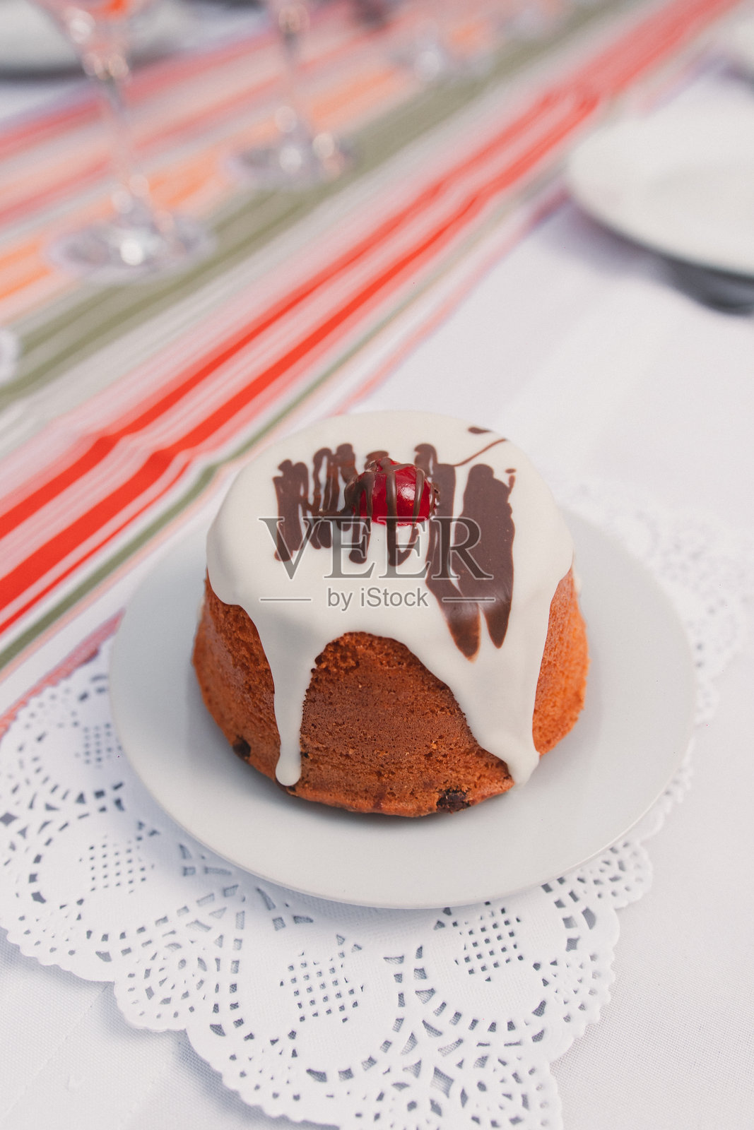 切开的布丁,上面覆盖着融化的奶油,放在长桌上的盘子里。照片摄影图片