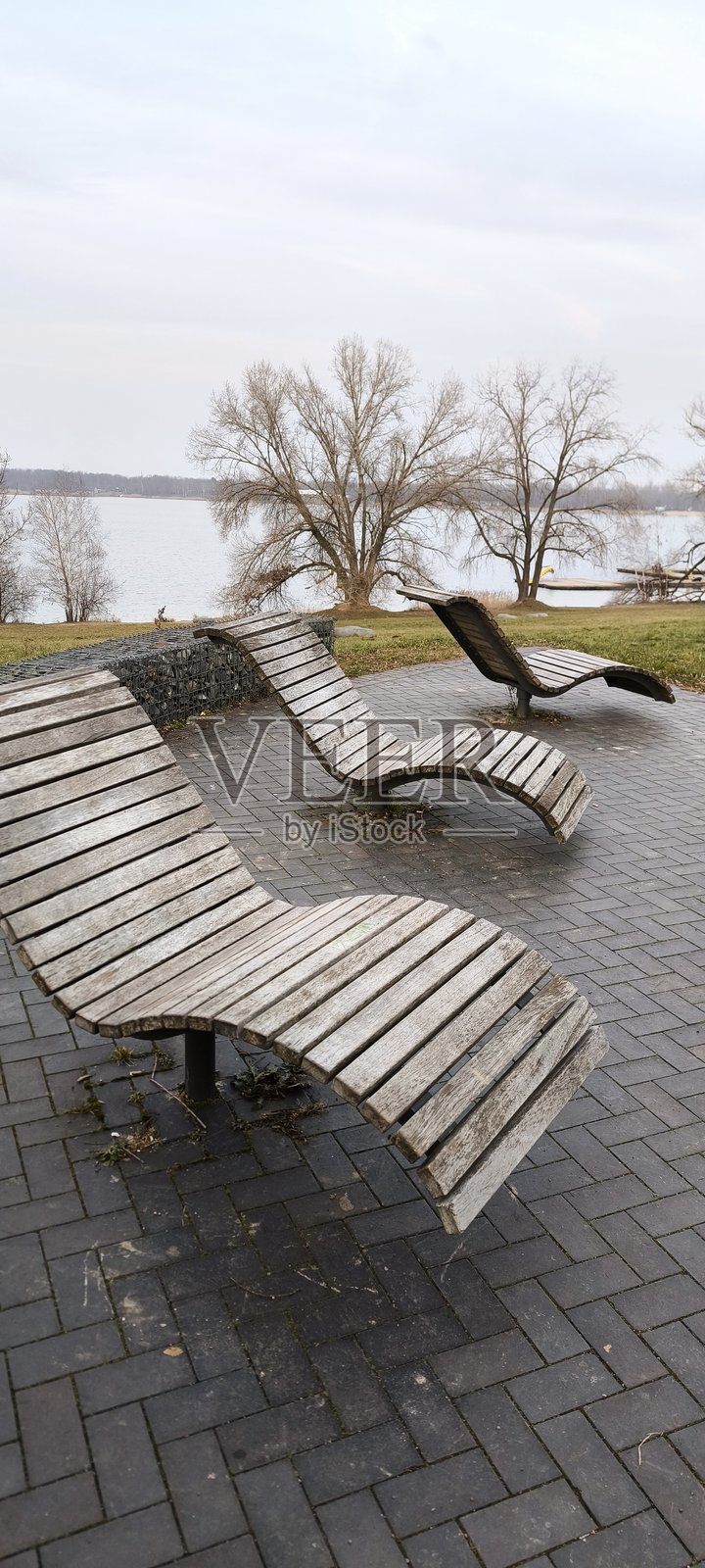 湖边景观上的木制长椅,形状如日光浴椅照片摄影图片