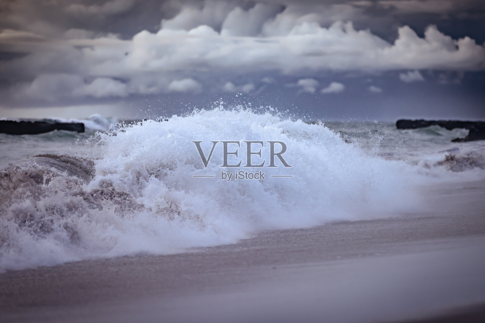 海洋上破碎的波浪与多云的天空背景。照片摄影图片