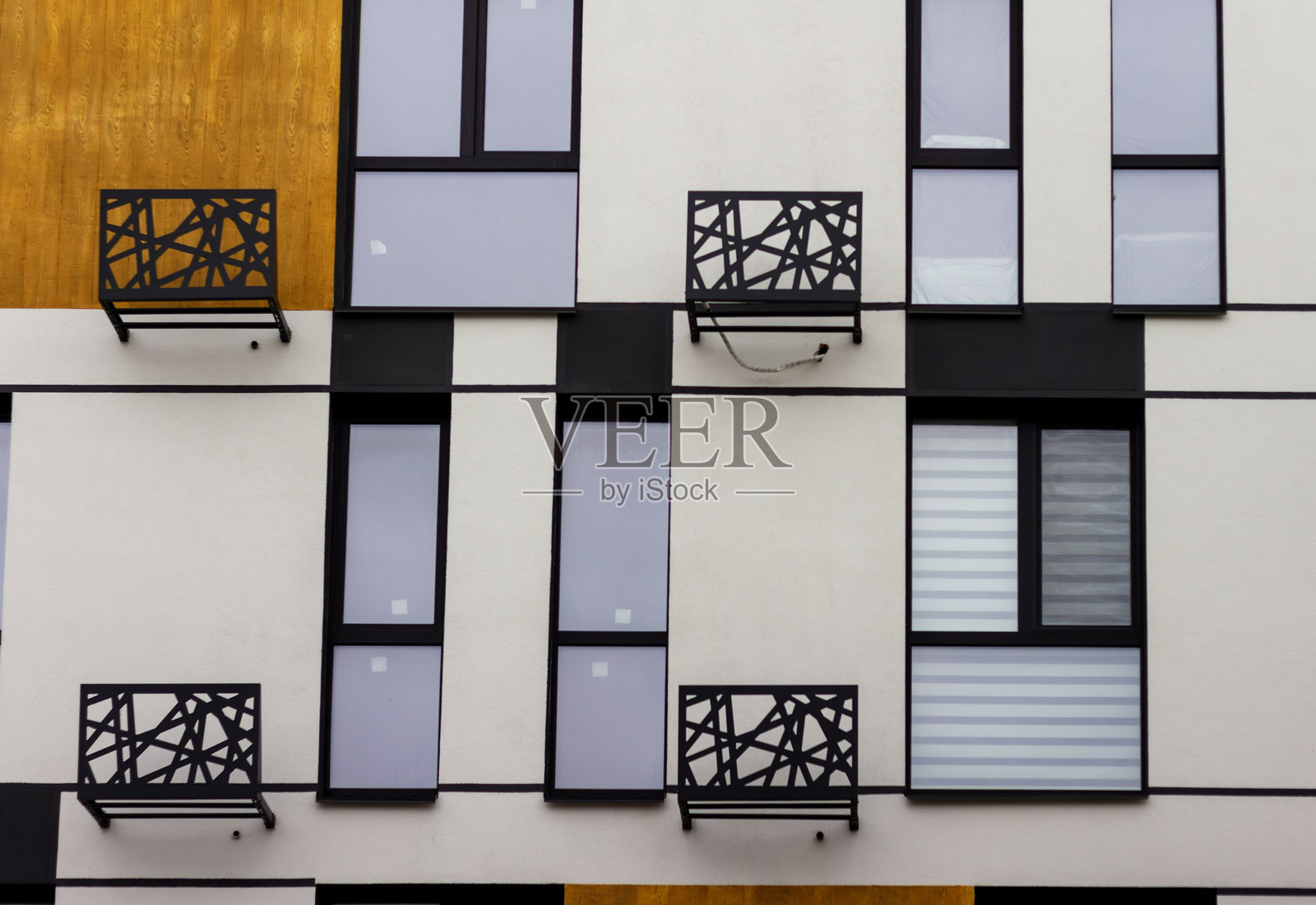 阳台装饰着精美的金属工艺,展示了混合材料住宅外立面的现代建筑风格。照片摄影图片