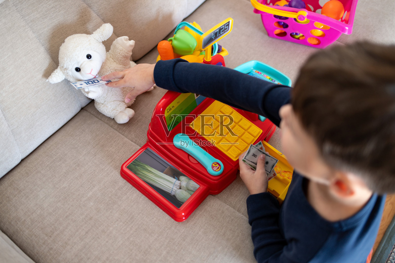 一个孩子在家里玩商店游戏。照片摄影图片
