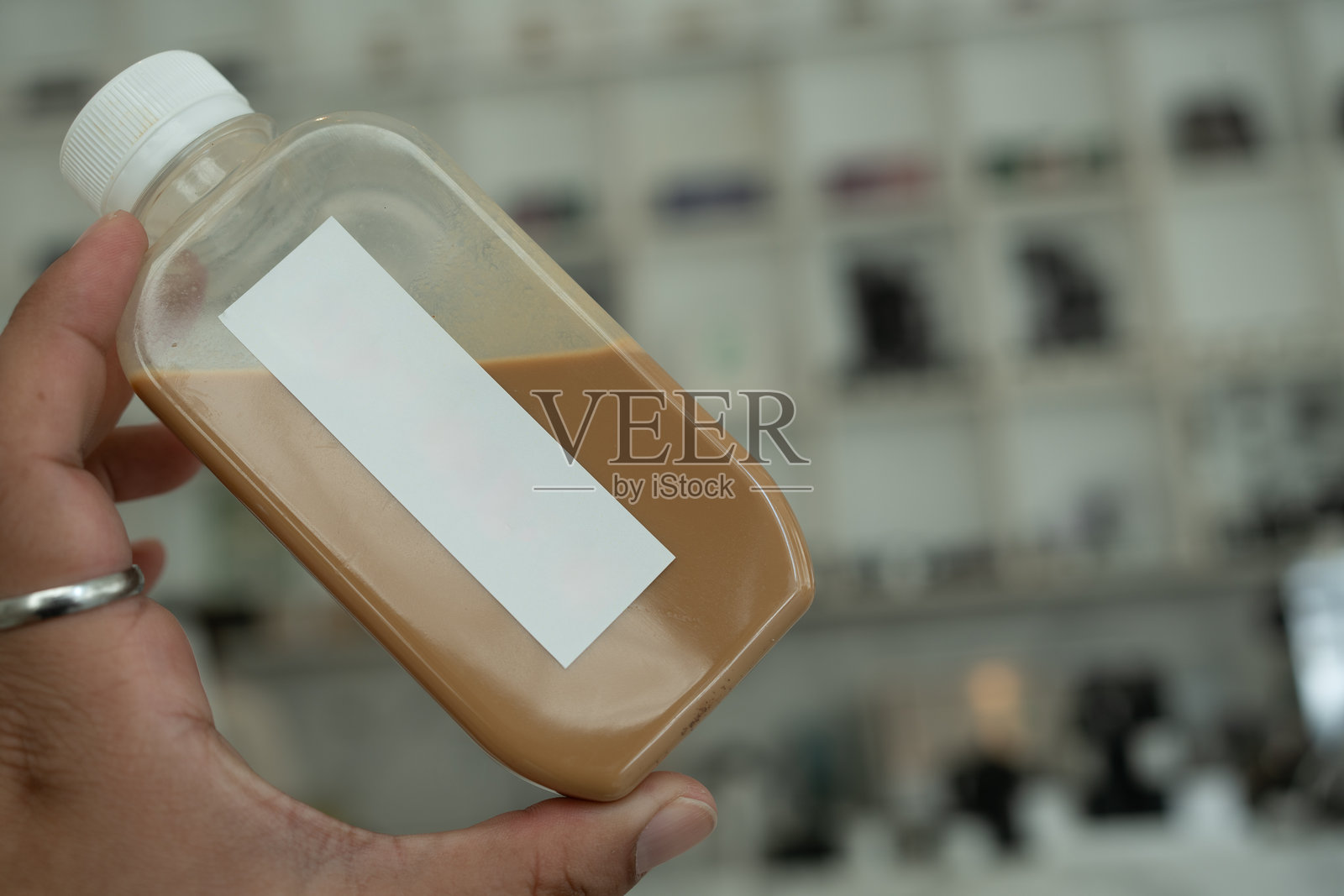 男子手持塑料瓶装咖啡产品照片摄影图片