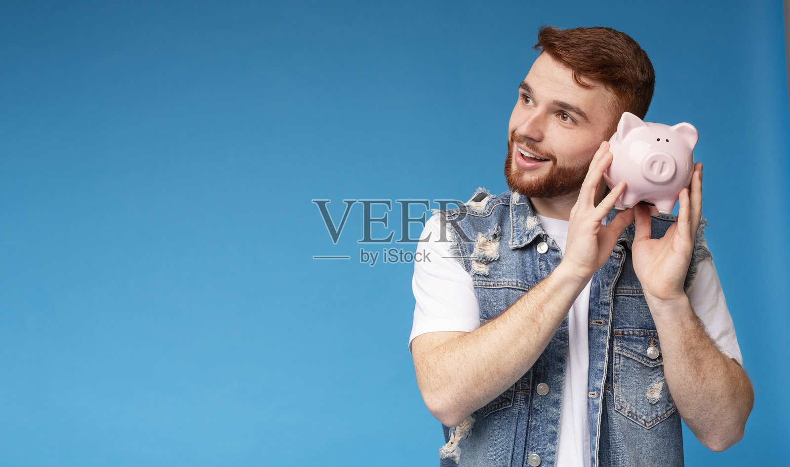 梦幻的千禧一代男孩在家里思考如何存钱照片摄影图片