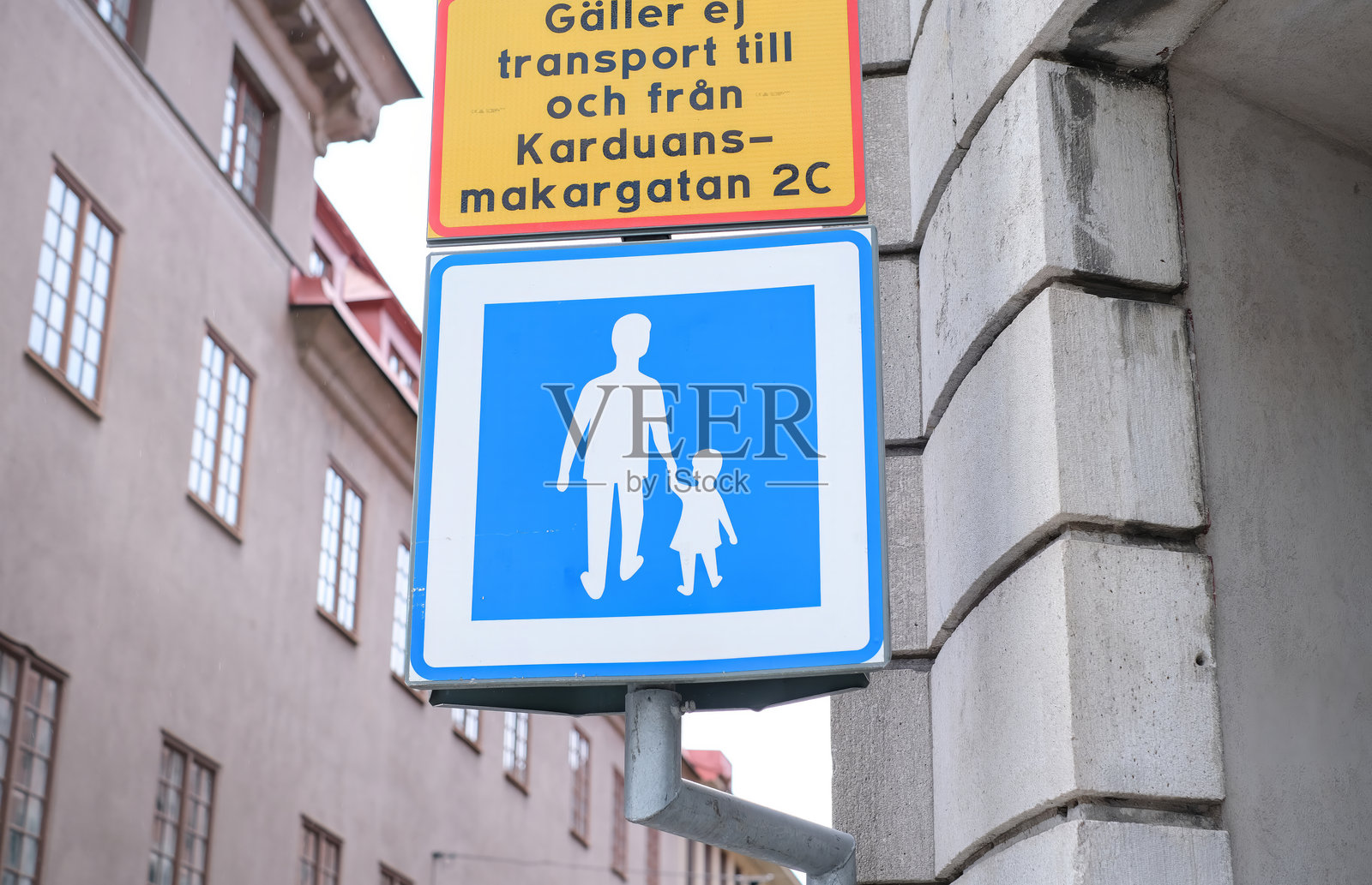 一个标志,上面有一个男人和一个孩子在走路。照片摄影图片