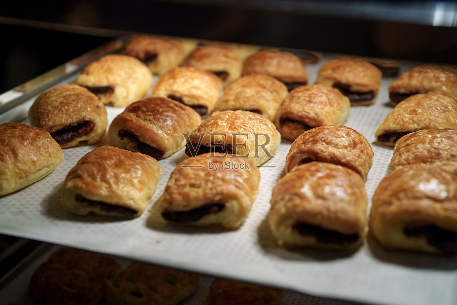 新鲜出炉的巧克力糕点在面包店里照片摄影图片