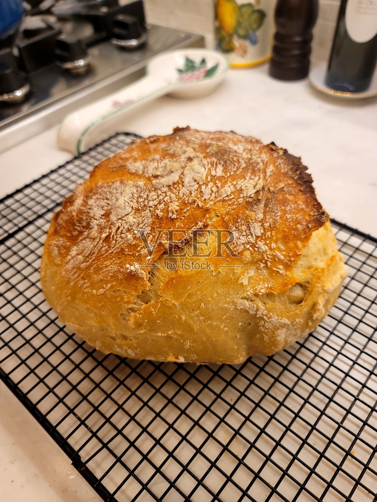 美味的自制面包刚从烤箱中取出,放在一个带盖的重铸铁锅里,外皮酥脆,非常适合热吃。照片摄影图片