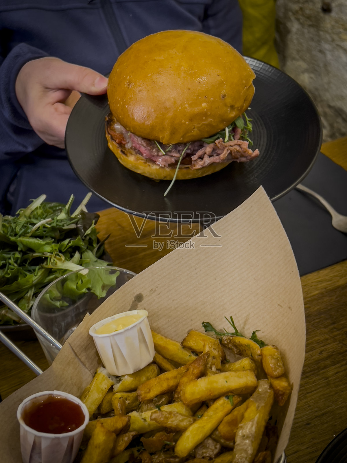 美味的汉堡配脆薯条,在舒适的环境中于午餐时段的休闲餐厅享用照片摄影图片