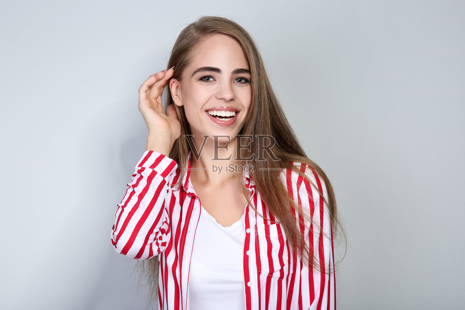 年轻漂亮的女孩在灰色背景上照片摄影图片