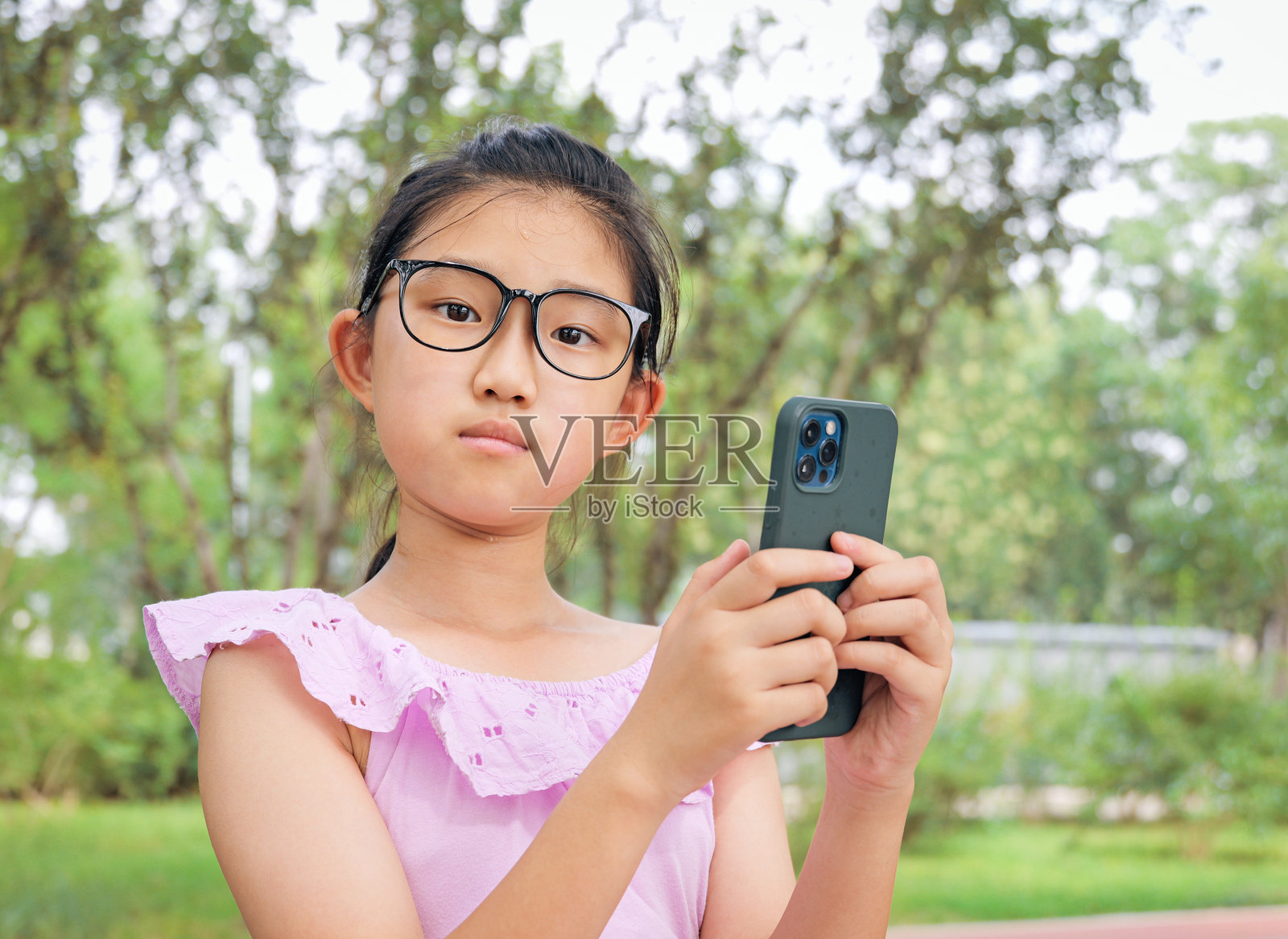 小女孩玩智能手机照片摄影图片