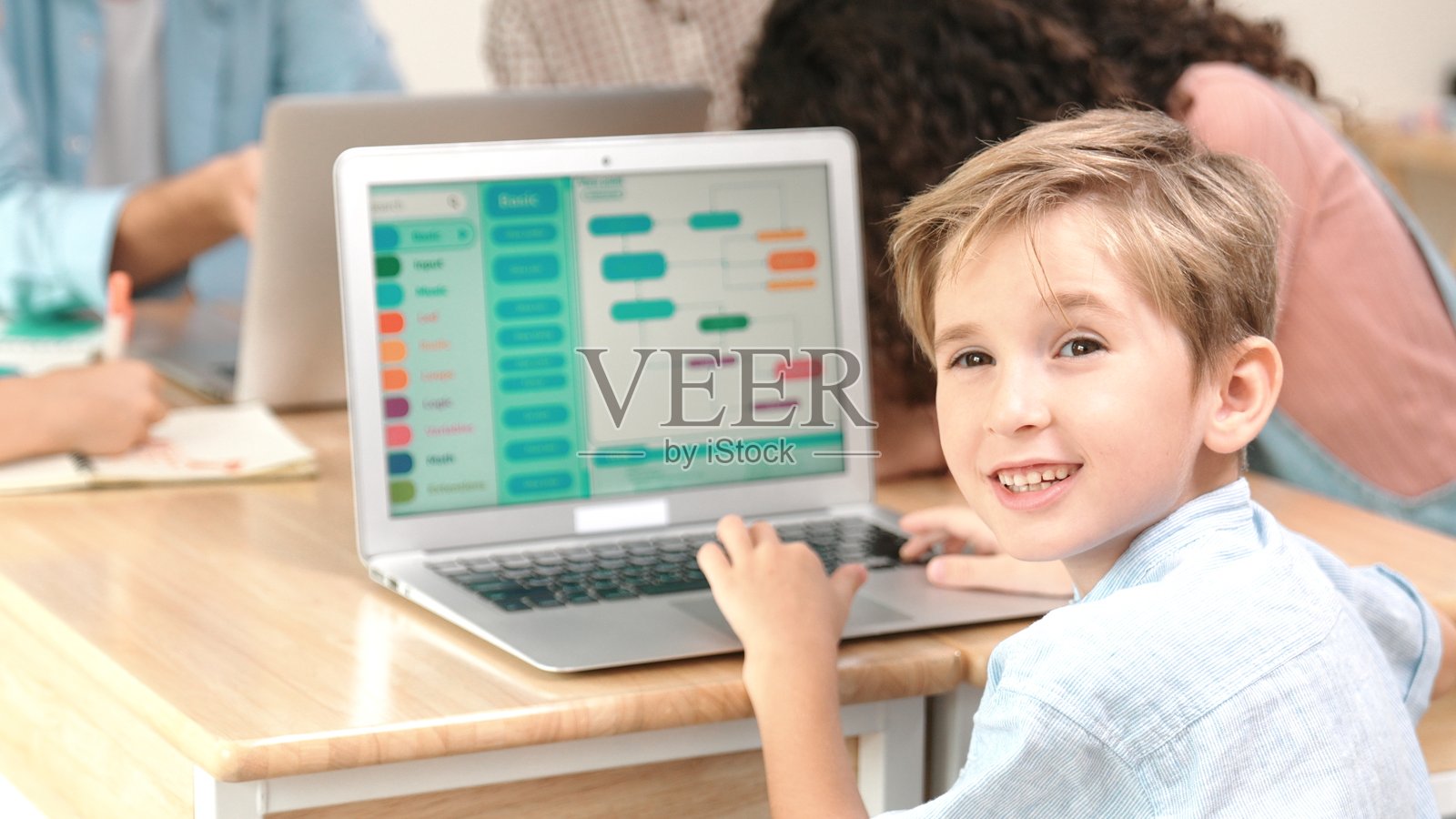 白人学生在STEM课堂上编码时看向镜头。教学法。照片摄影图片