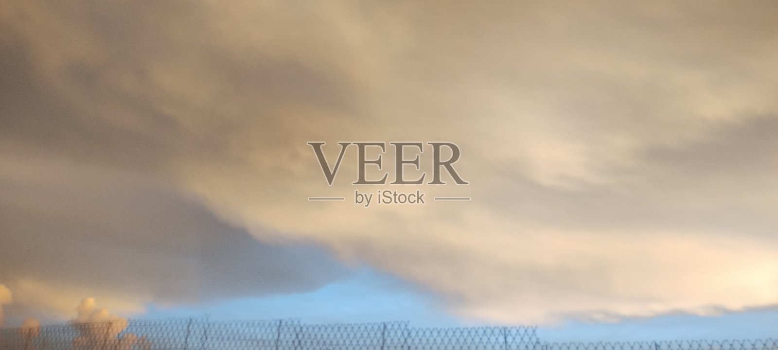 公寓小区内的绿地,背景是明亮的云朵,拍摄于傍晚时分。照片摄影图片