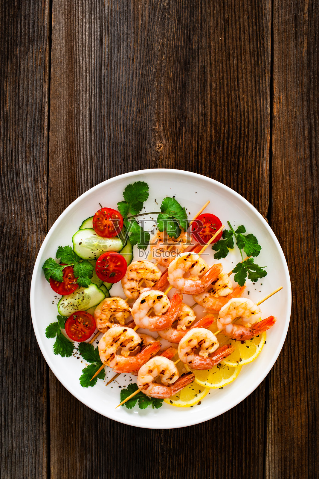 烤虾串和新鲜蔬菜摆放在木桌上照片摄影图片
