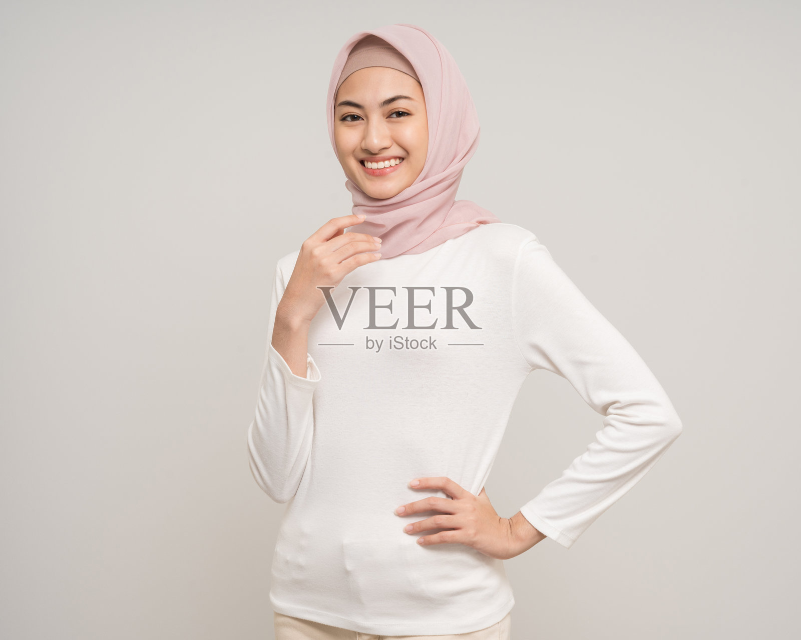 快乐的年轻亚洲穆斯林女性站在白色背景前。美丽迷人的穆斯林女性穿着时尚的阿巴亚和头巾,在摄影棚拍摄。照片摄影图片