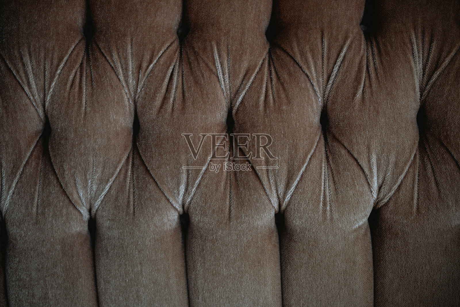 温馨环境中带有纹理的棕色绒面布料的绗缝表面照片摄影图片