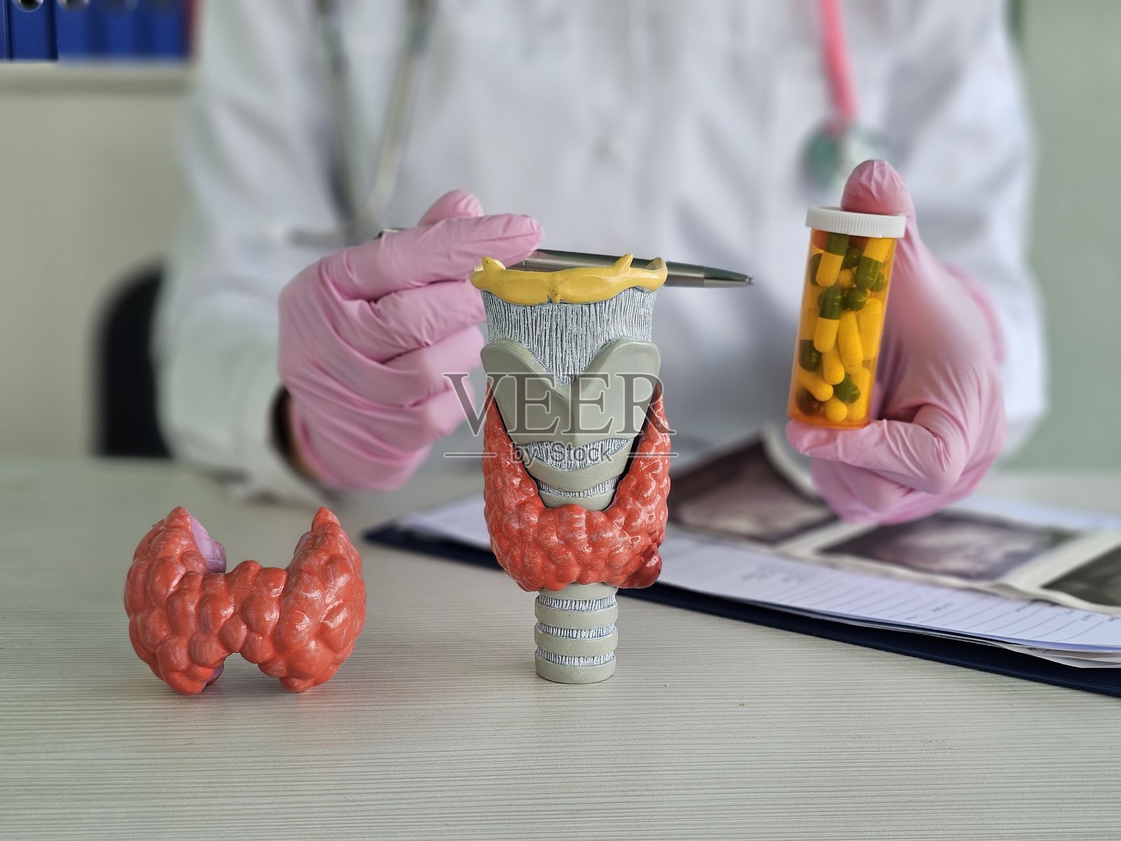 医生手持治疗甲状腺疾病的药片。甲状腺治疗概念,激素疗法,碘疗法,内分泌学概念。照片摄影图片