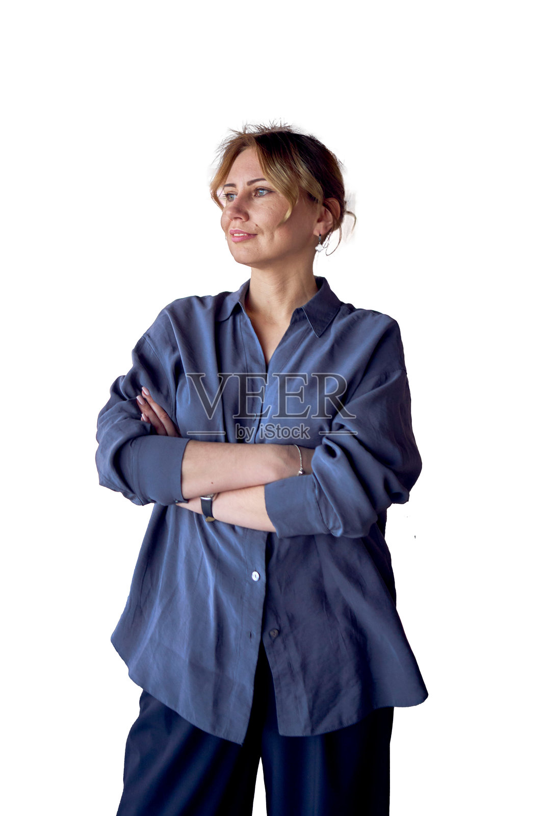 一位迷人的中年女性,双臂交叉,站在现代化的共享办公空间中,穿着宽腿裤和丝绸衬衫。照片摄影图片