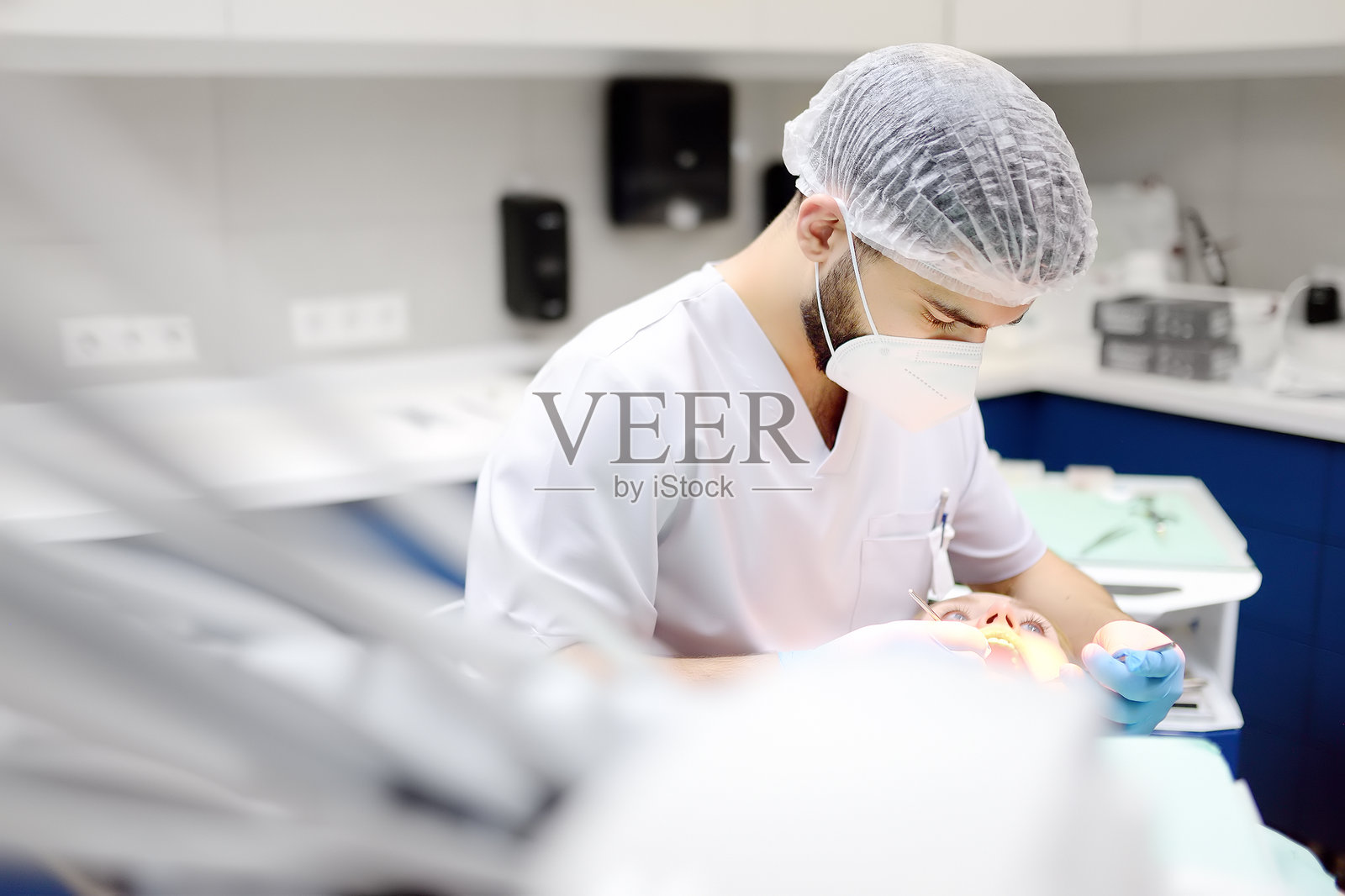 现代医疗中心的牙医与患者。医生在医院为年轻女性治疗牙齿。医生在进行正畸或修复治疗前检查患者。照片摄影图片