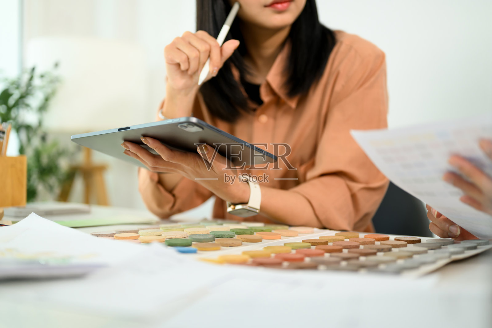 两位室内设计师正在合作项目,使用数字平板电脑并查看颜色样本。照片摄影图片